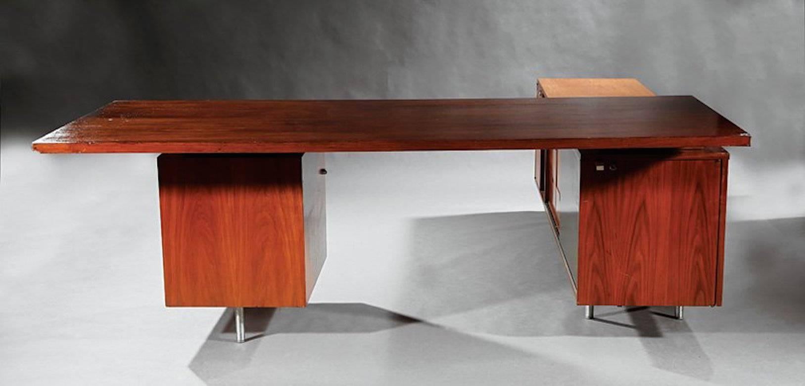 Handsome desk by George Nelson for Herman Miller. Metal legs, walnut return and walnut desktop. Return has multiple shelves and five wood pull-out drawers including a file drawer. Sliding doors can be left open on both sides of return allowing to