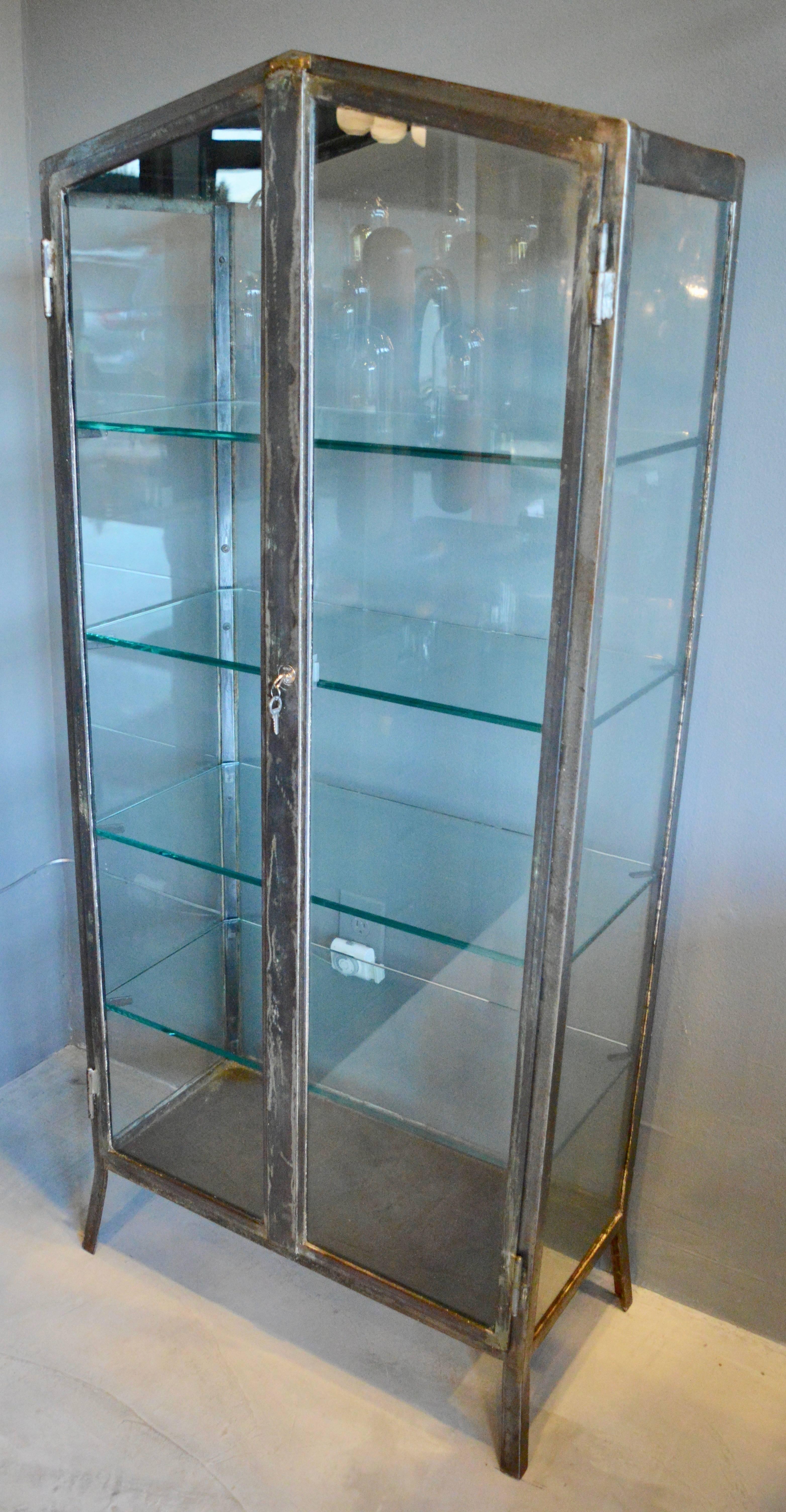 Very rare matching pair of iron and glass vitrines from the 1930s. Handcrafted in Buenos Aires, with all original hardware and glass frame. Newly made thick glass shelves with notched corners to fit snugly inside. Fantastic locking mechanism inside