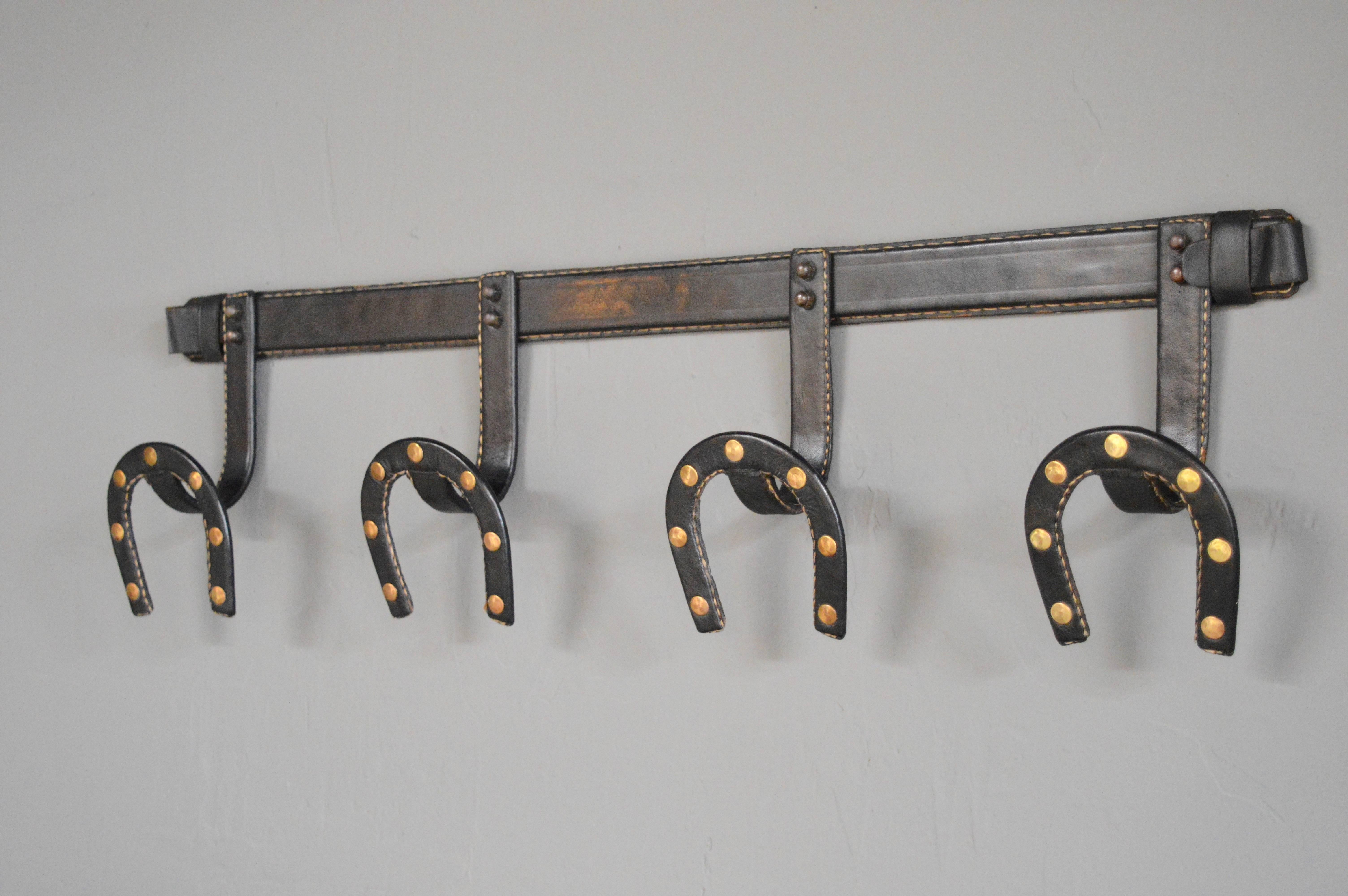 Handsome leather horse shoe coat rack by French designer Jacques Adnet. Excellent vintage condition. Gorgeous piece of wall art!