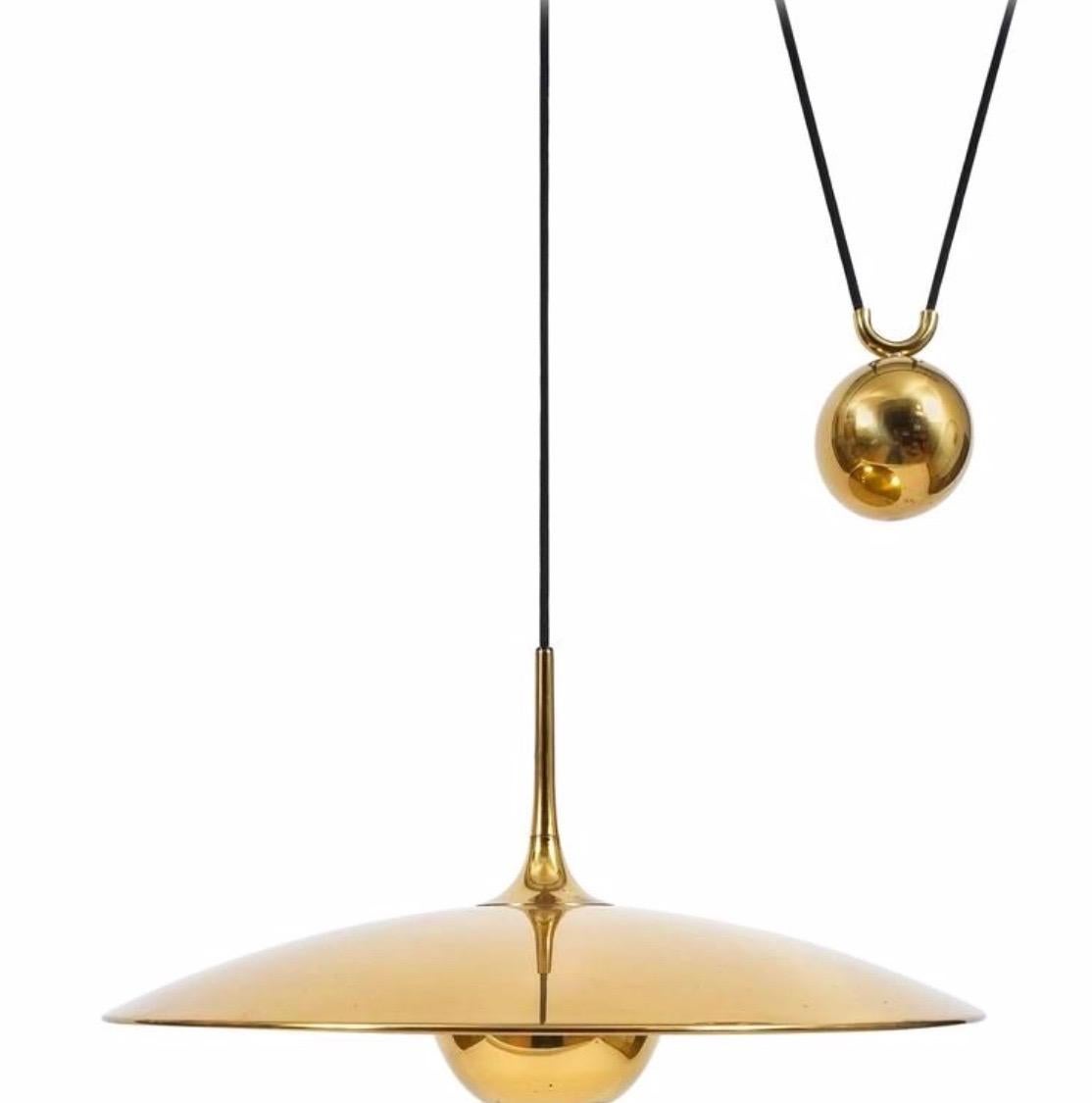 Great Florian Schulz double counter balance light in brass. Features two brass shades with 21.5 diameter, two brass ball counter-weights, brass canopy and hardware. One single j-box needed in the center. Black cloth cord. Both lights move up and
