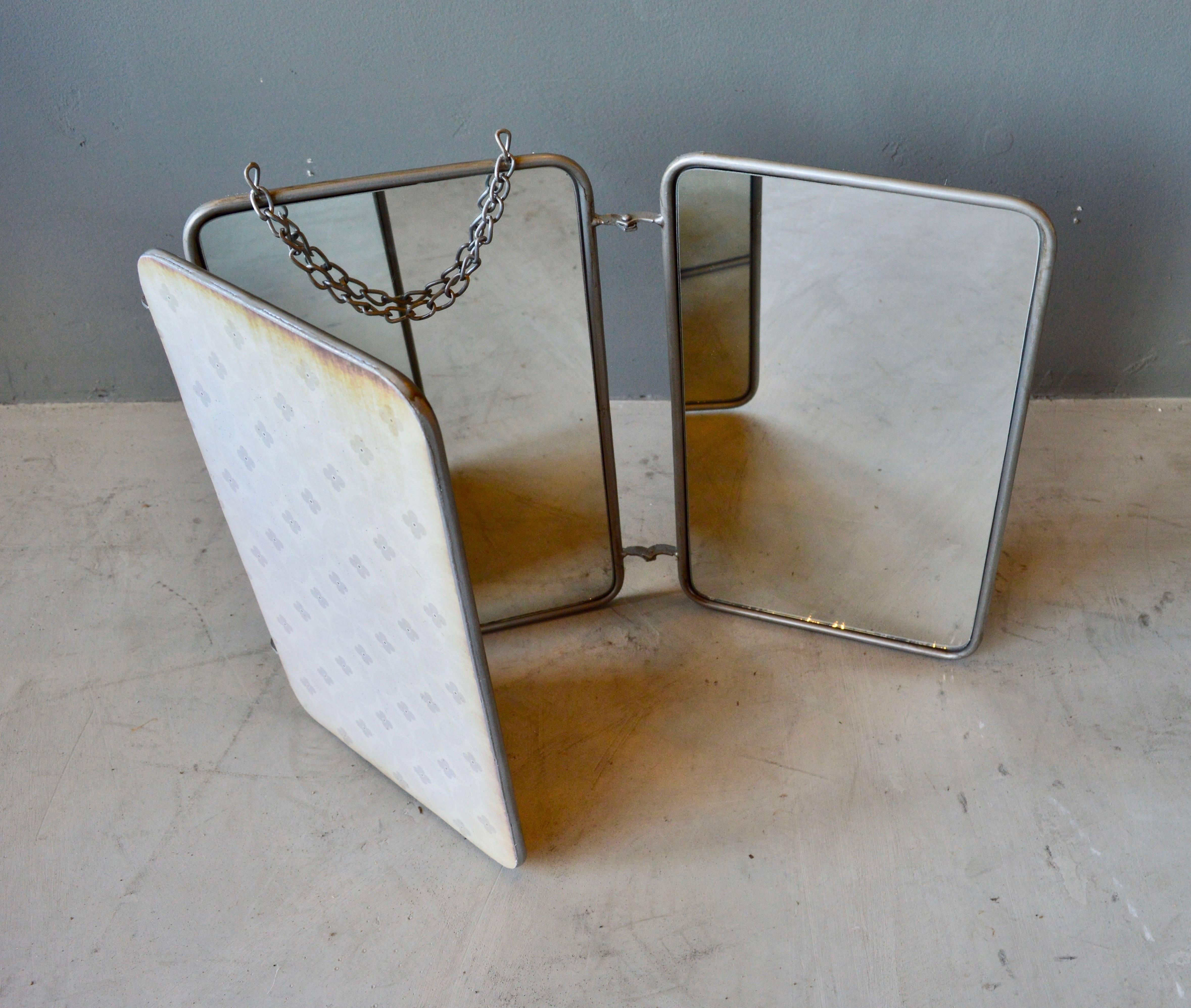 Interesting French triptych barber's mirror. Chrome and glass in good condition. Suspended from a chain. Opens and closes. Unique piece and great bathroom mirror or wall art.