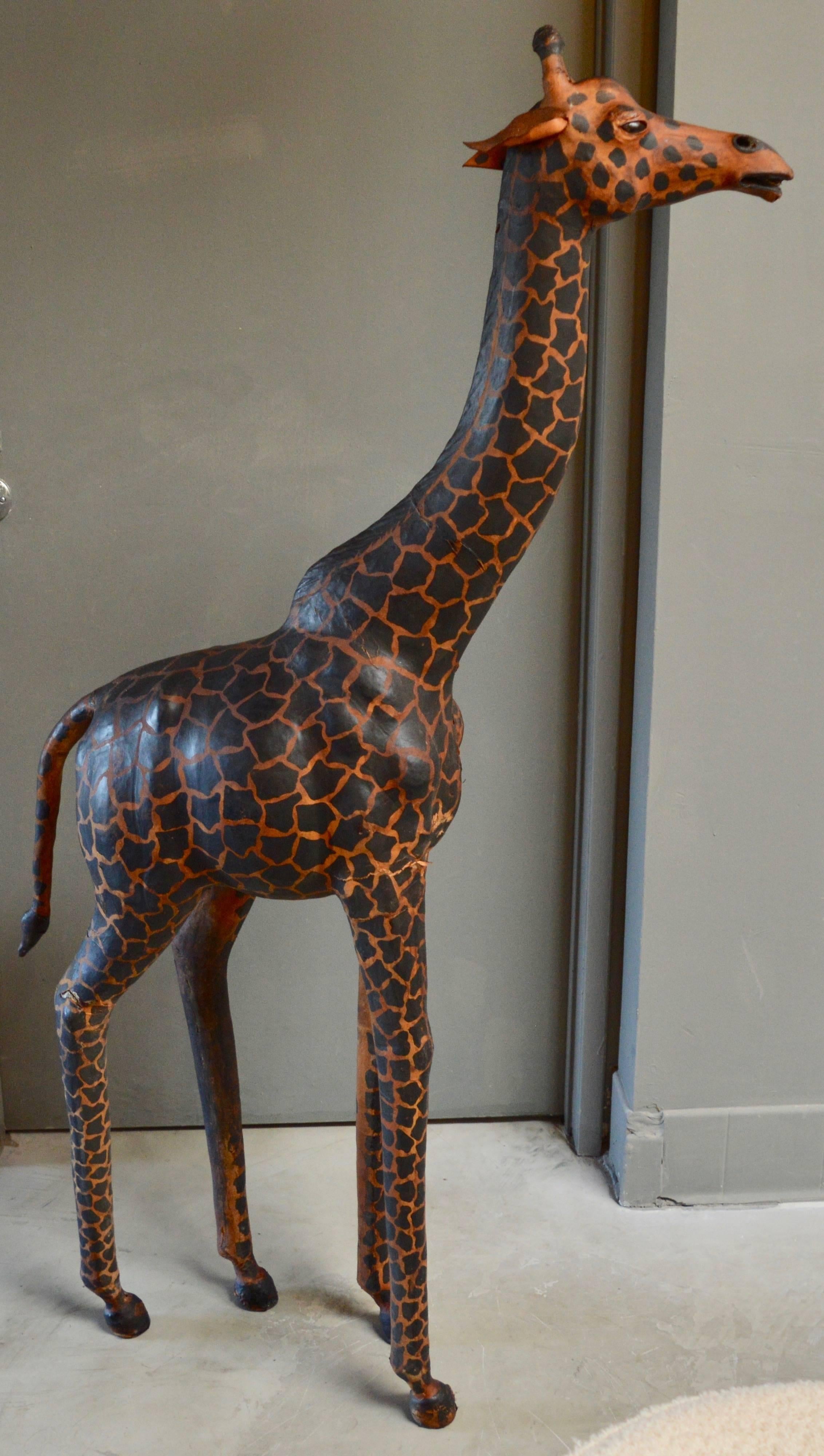 Stunning pair of leather giraffes. Large adult with child. Some discoloration and slight losses to leather. Overall in very good condition. Great piece of art!

