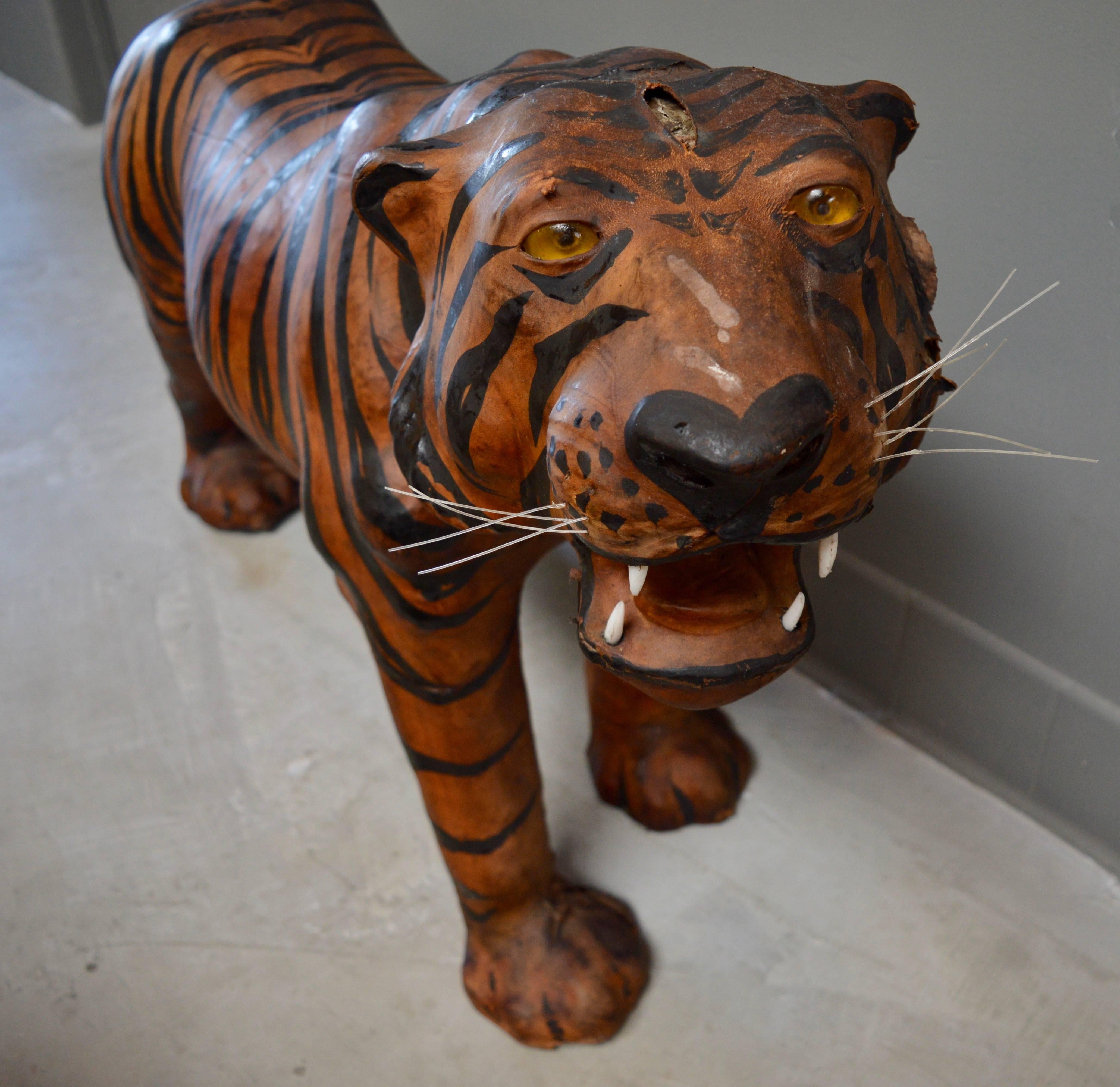 Massive leather tiger sculpture. Great detailing with glass eyes, whiskers and teeth. Losses and splits to leather throughout. Very unique object. Pair of leather giraffes available in separate listing. Great kids room or play room item.