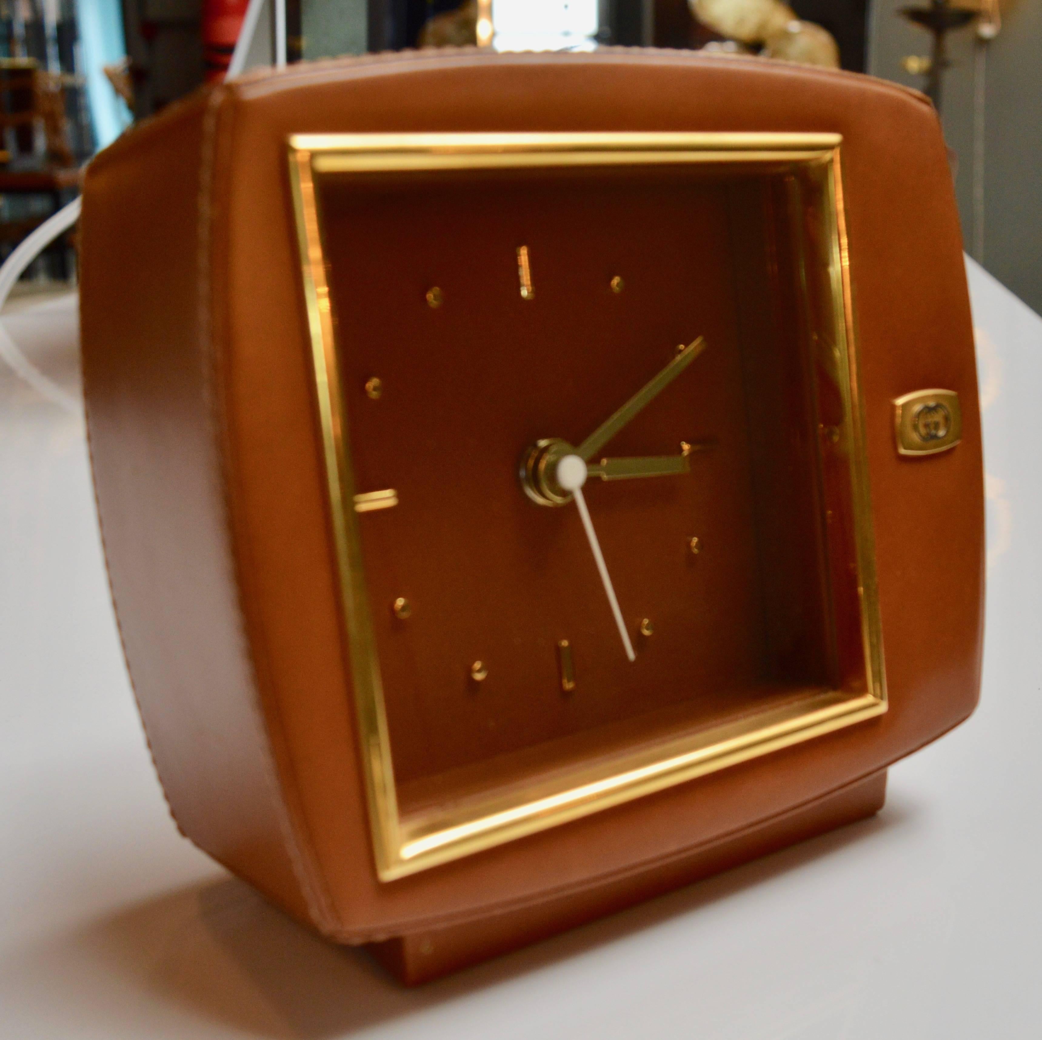Gorgeous leather and brass table clock by Gucci. Great age and color to leather. Brass in excellent condition. Clock is in great working order. Double G brass logo on front. Gucci Italy label on bottom. Excellent condition overall.