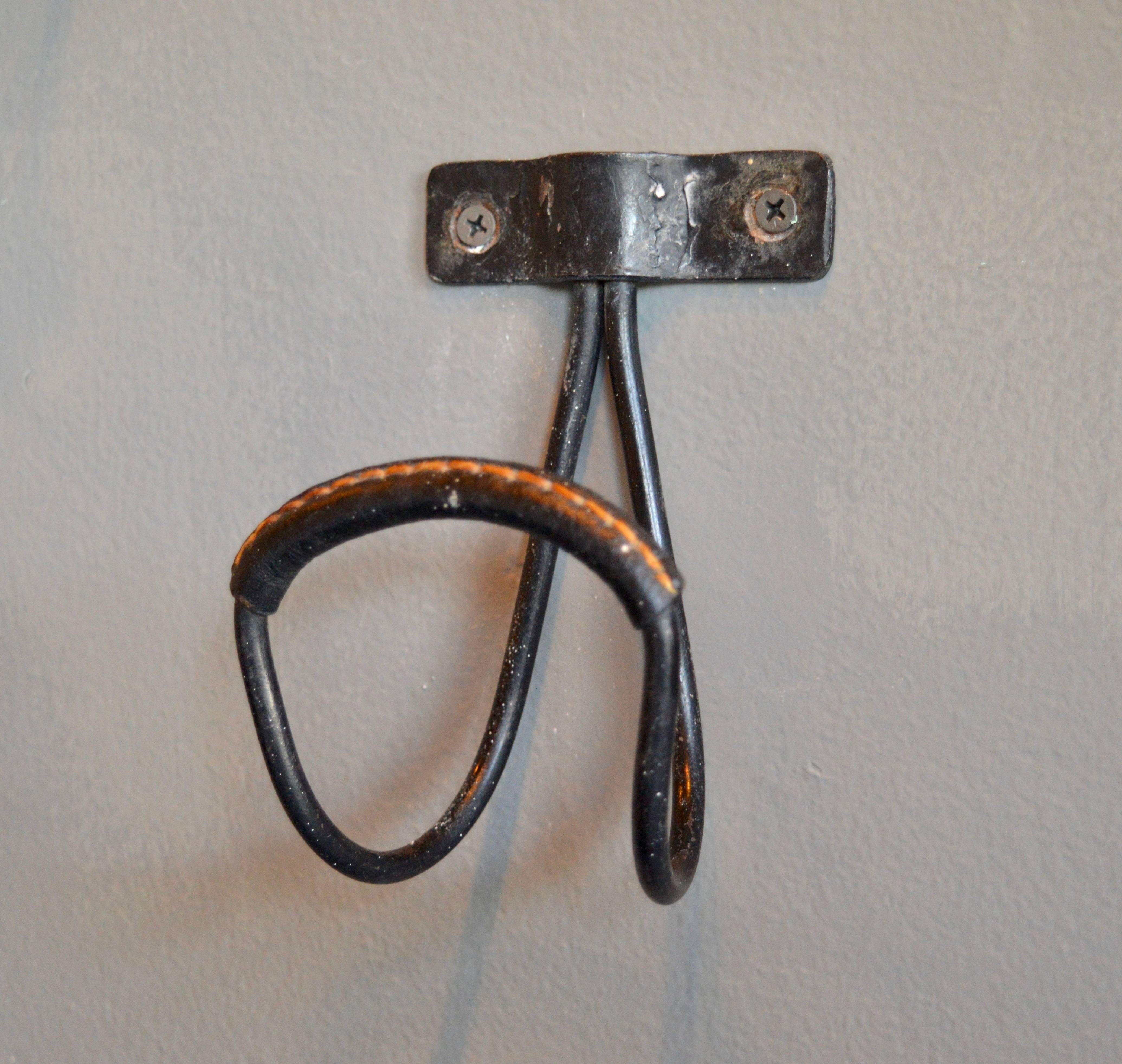 Excellent hook by French designer Jacques Adnet. Iron frame with black leather wrapped hook. Signature Adnet contrast stitching. One available. Similar hook in saddle leather also available in separate listing. Matching double hook available in