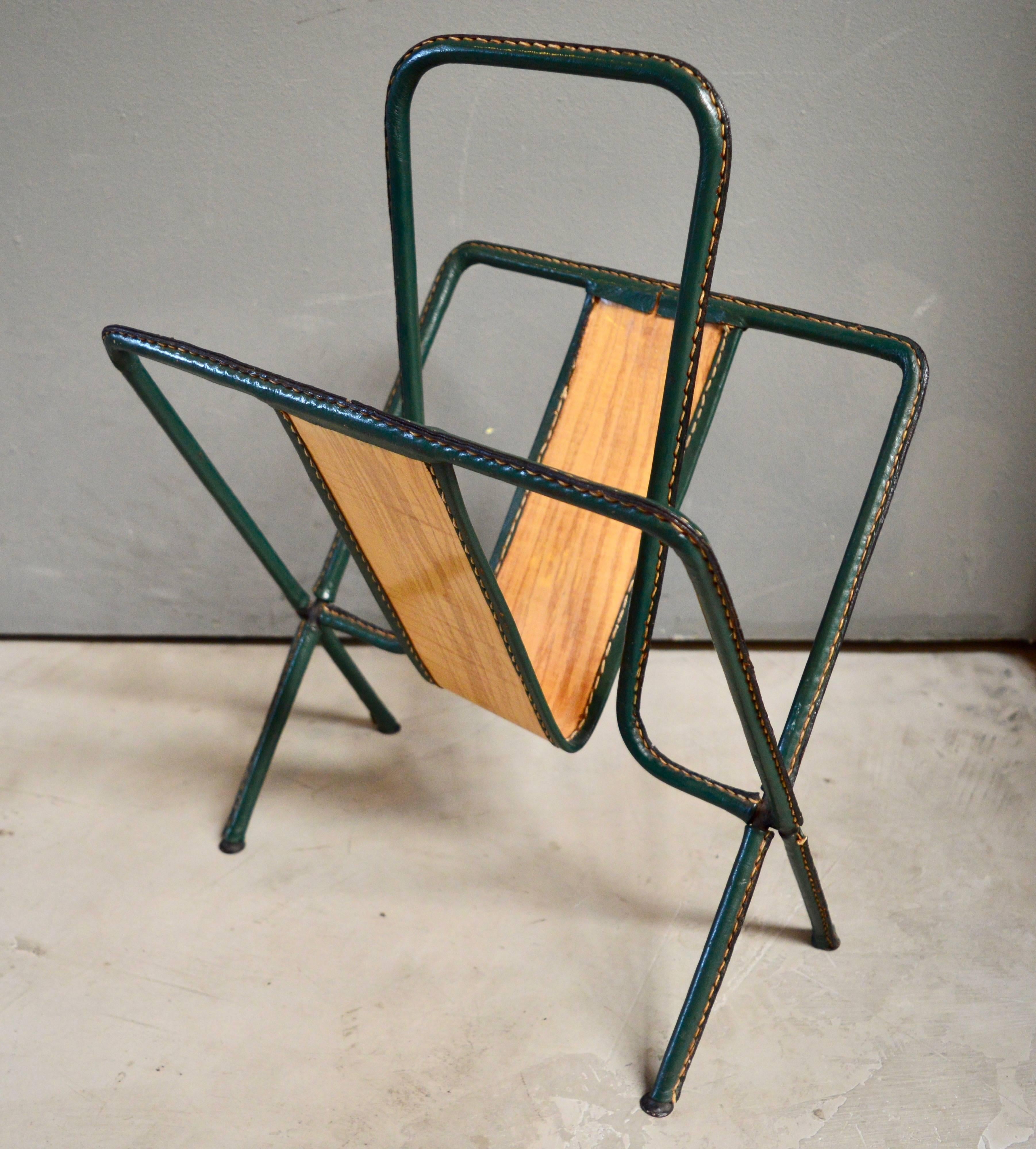 Very rare magazine rack entirely wrapped in green leather by Jacques Adnet. Inlaid wood in the middle of the rack. Very rare piece. Excellent vintage condition.