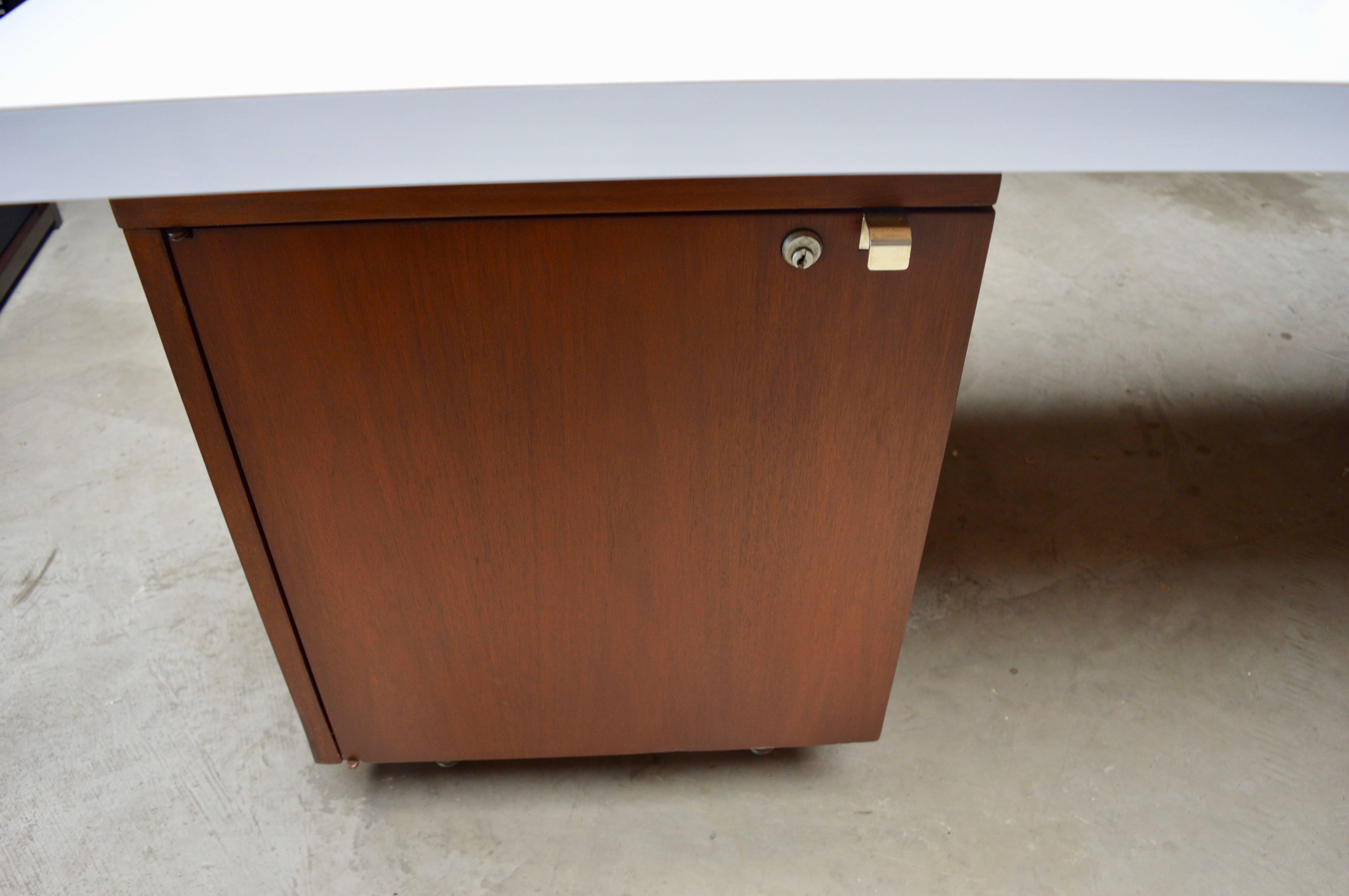 Fantastic desk by George Nelson for Herman Miller. Newly laminated Formica top with dry erase laminate. Very cool, dry/erase surface for your work desk. Extremely functional and unique feature. Walnut desk with chrome hardware. Two drawer pedestal