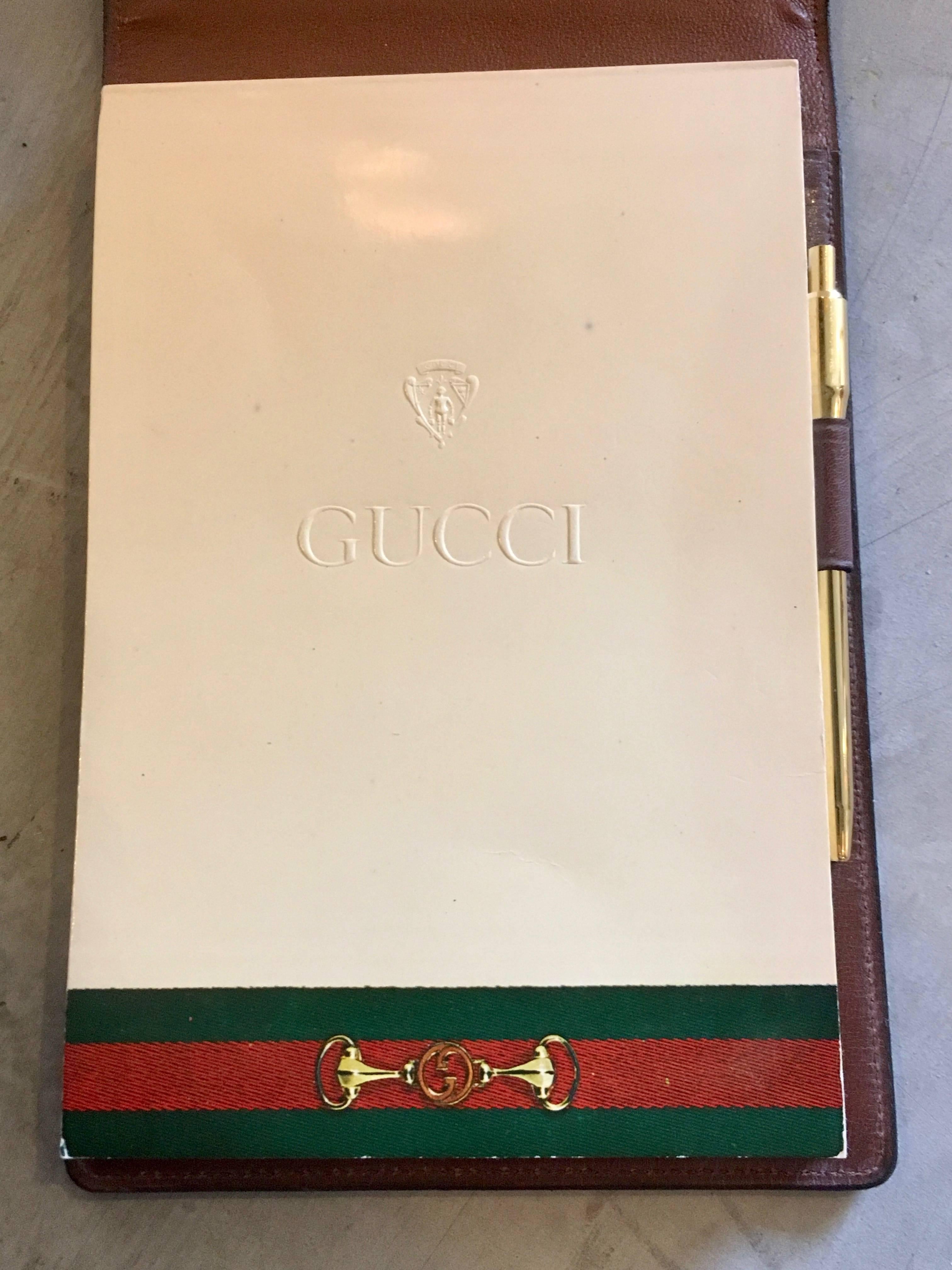 Handsome vintage saddle leather Gucci notepad with brass stirrup. Excellent patina to leather. Original, unused notepad inside with pen and storage. Pen needs new cartridge. Great piece for the desktop or on the go.