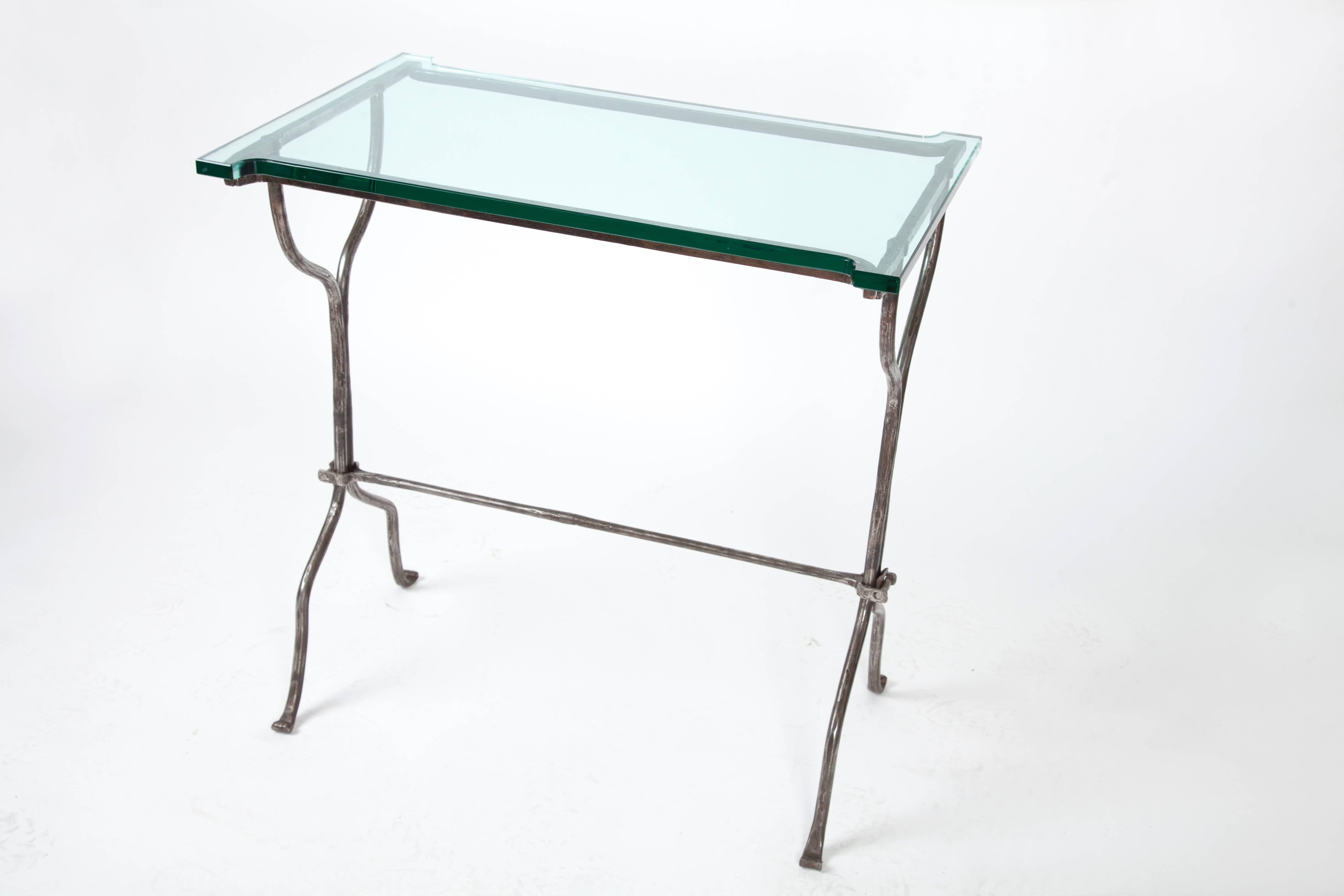 Hand-forged iron desk with a thick glass top.