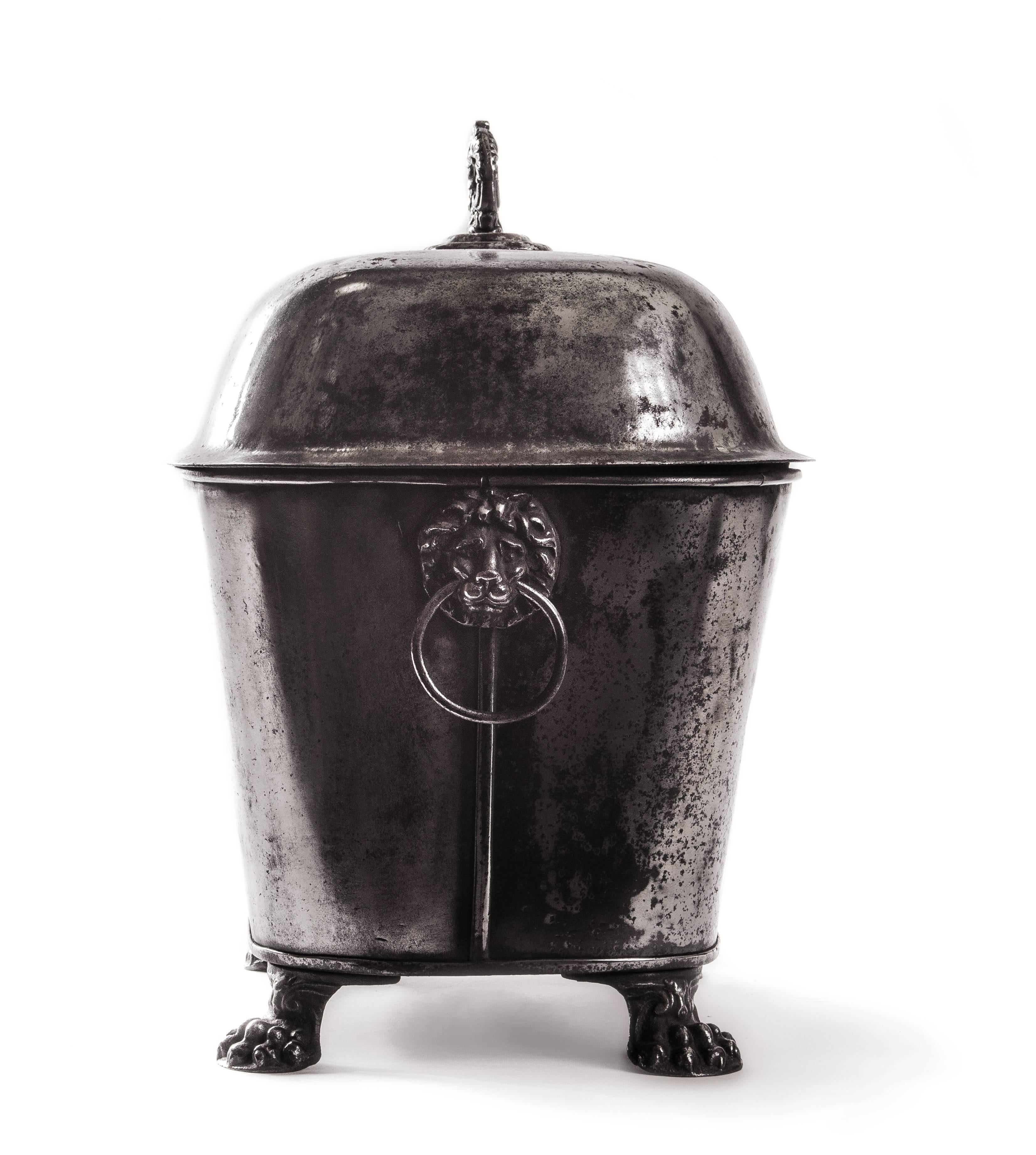 19th century English coal scuttle. Polished steel. Raised on four claw feet. Two lion decorated handles.