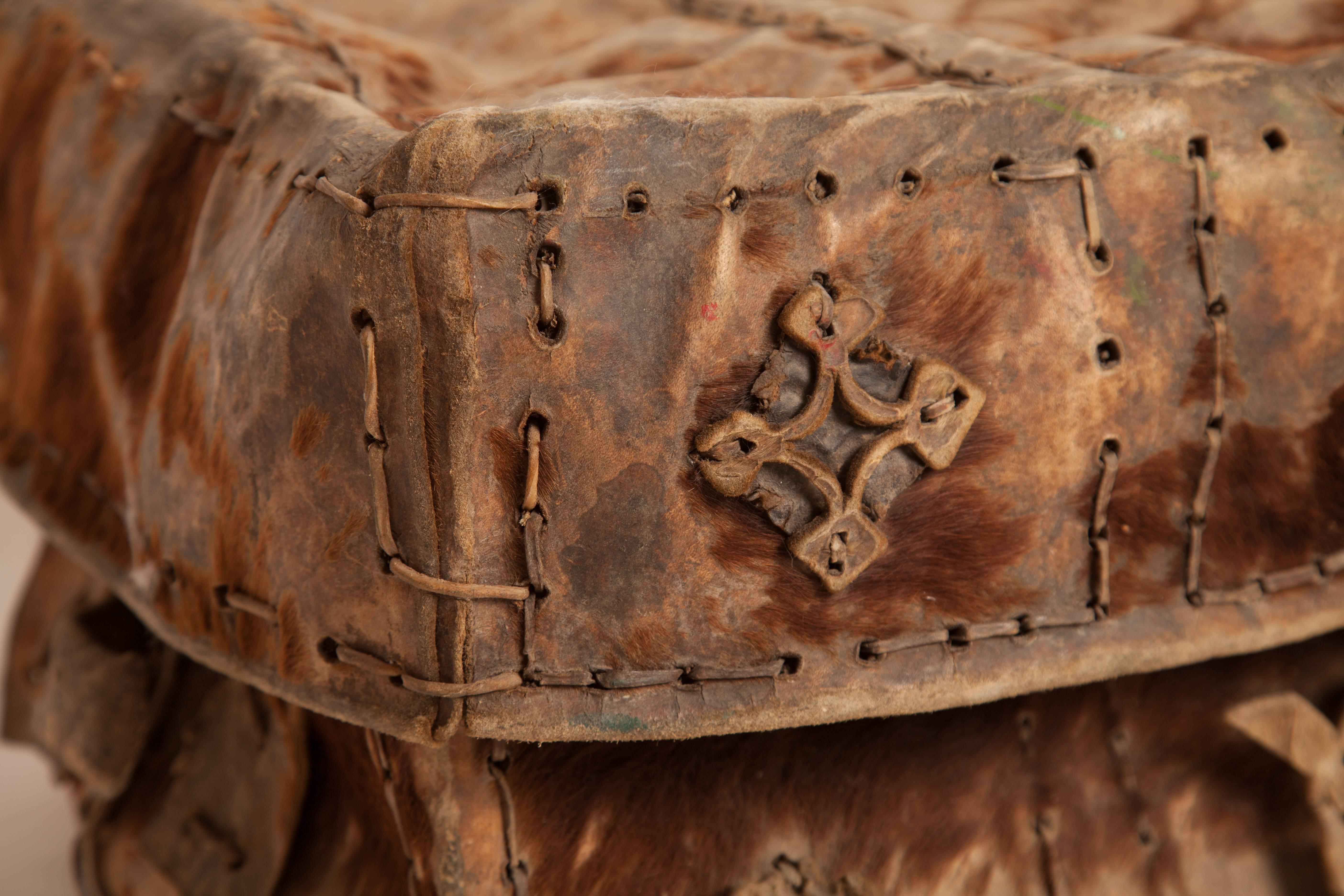 19th century Mexican petaca, made from hair on hide leather, with leather rosettes, handles, and decorative stitching.