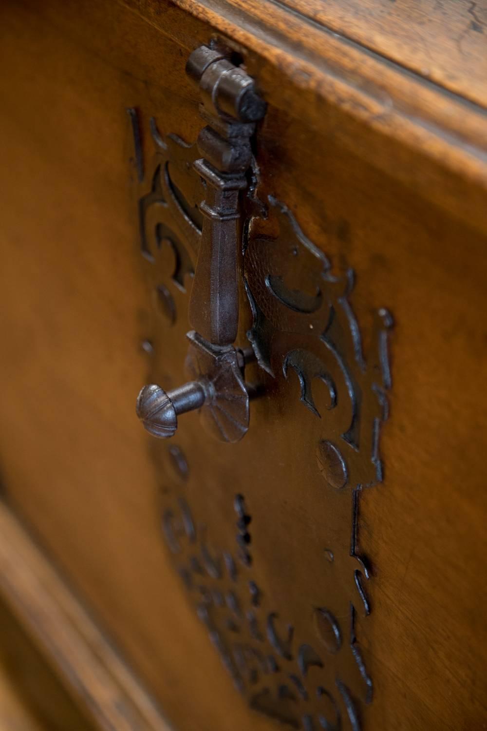 Walnut safe chest with iron lock and iron strap details, 18th century Spanish. Raised on four bun feet.