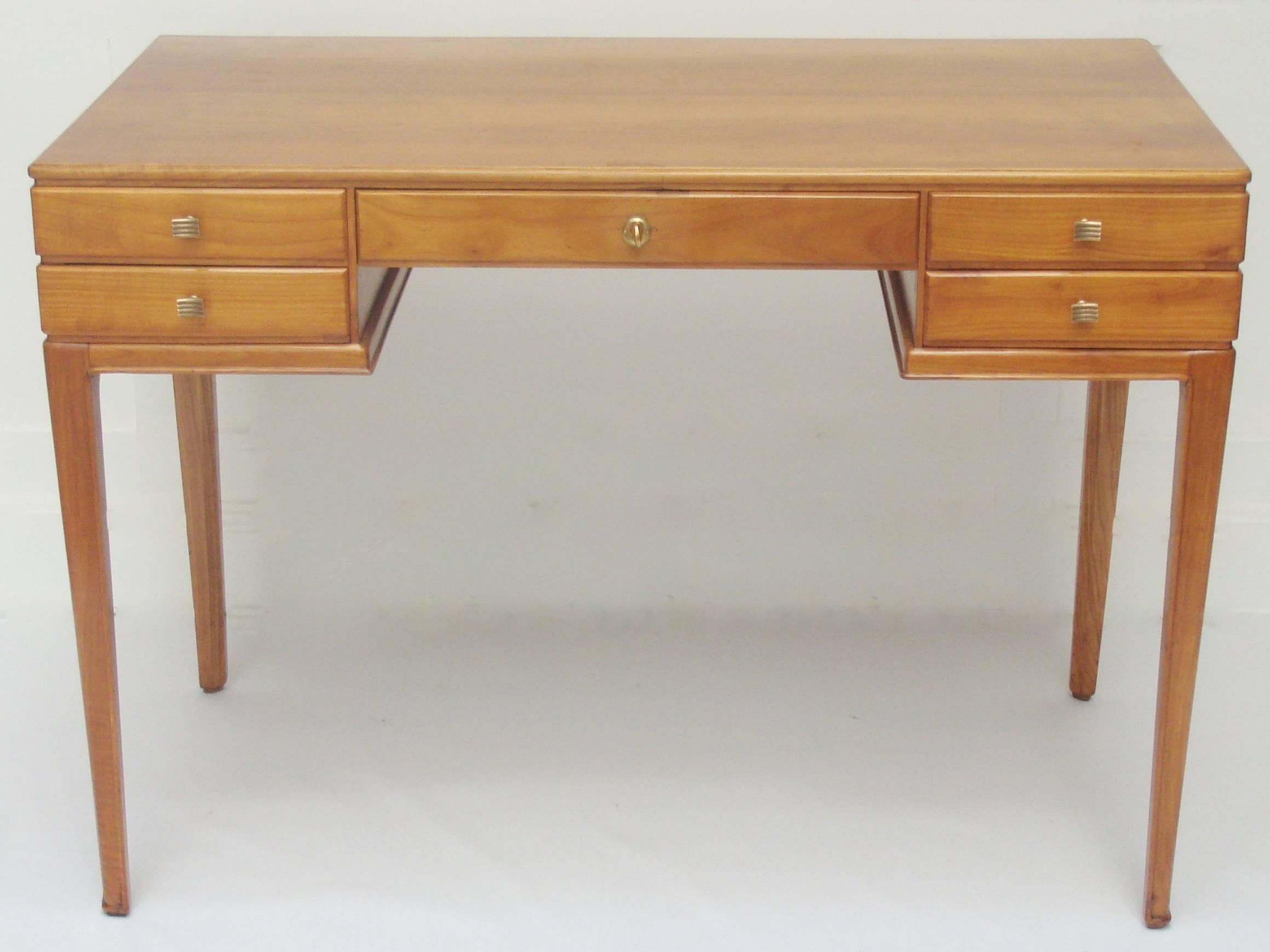A five-drawer cherrywood writing desk with brass details attributed to Guglielmo Ulrich.  