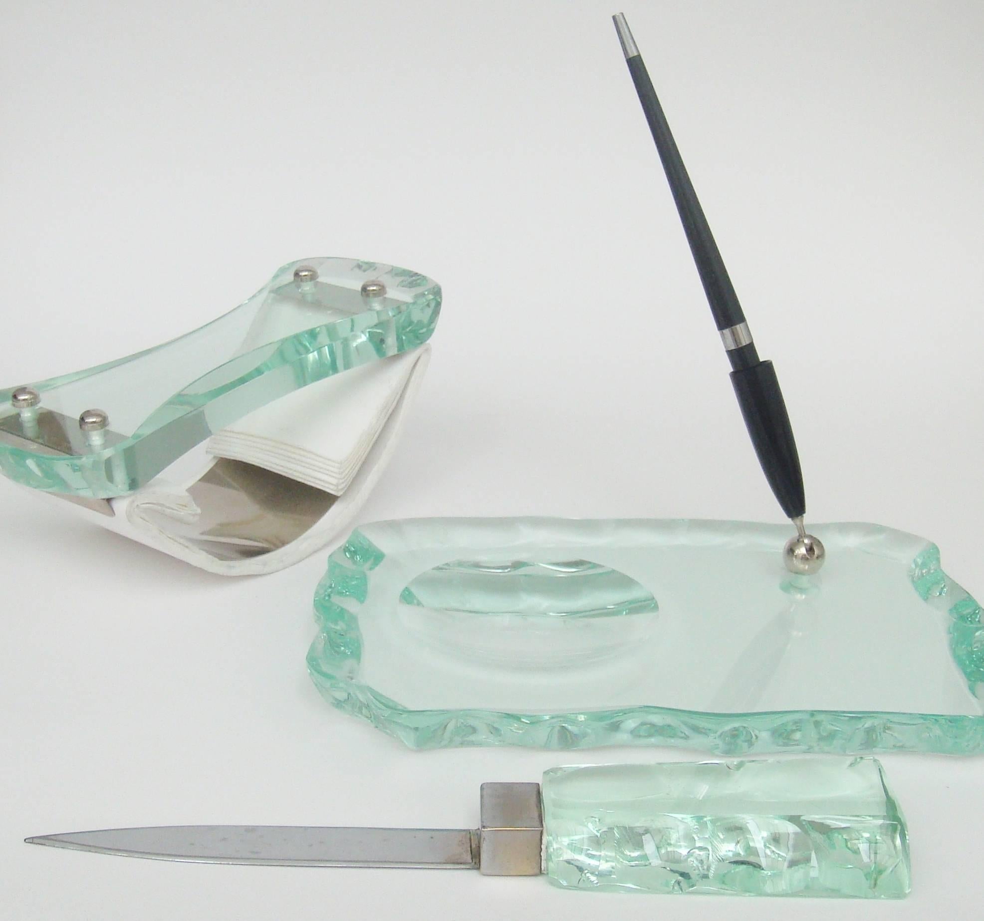 A chiselled glass desk set in the style of Fontana Arte comprising,
a pen stand, letter opener and blotter.