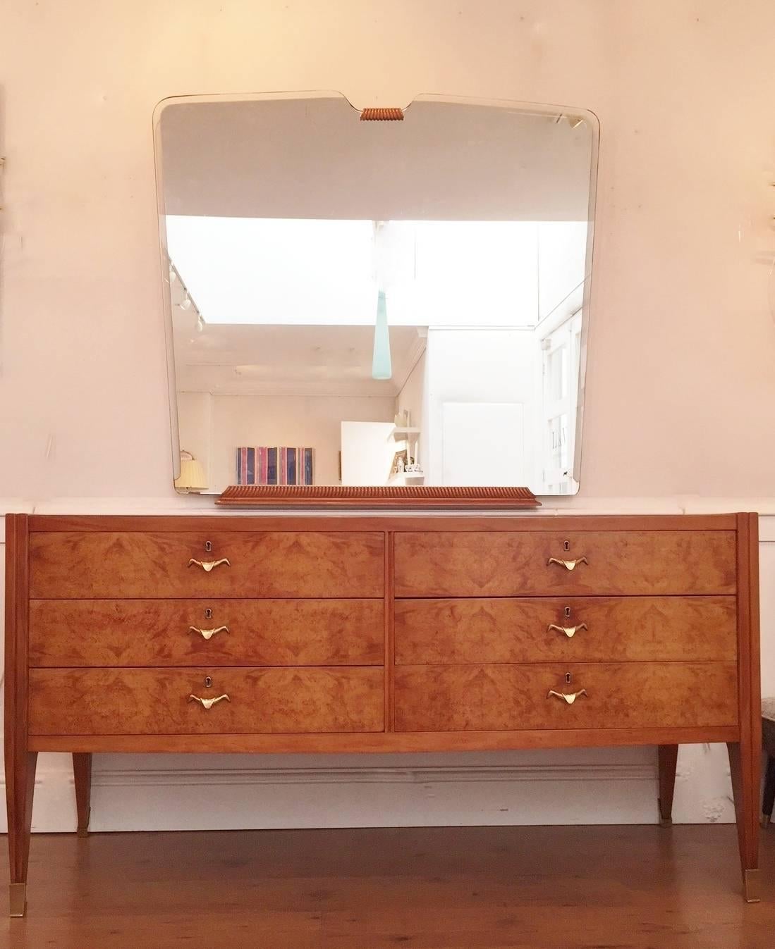 A six-drawer sideboard with glass top, brass handles and sabots together with a matching mirror attributed to Paolo Buffa.

Mirror: 42 x 45 ½ in / 107 x 115 cm.
 