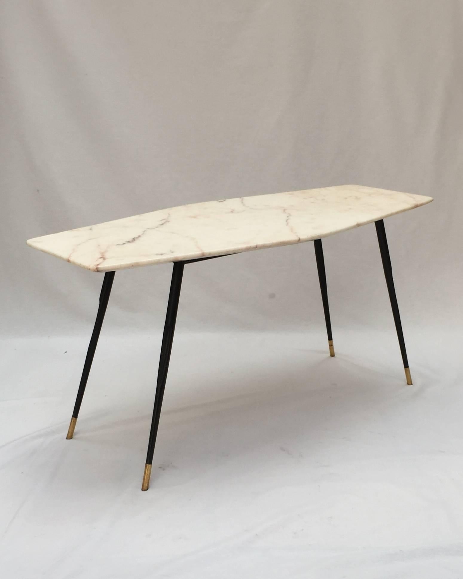 A marble coffee table with brass tipped black
lacquered metal legs by Galli Cantù.
 