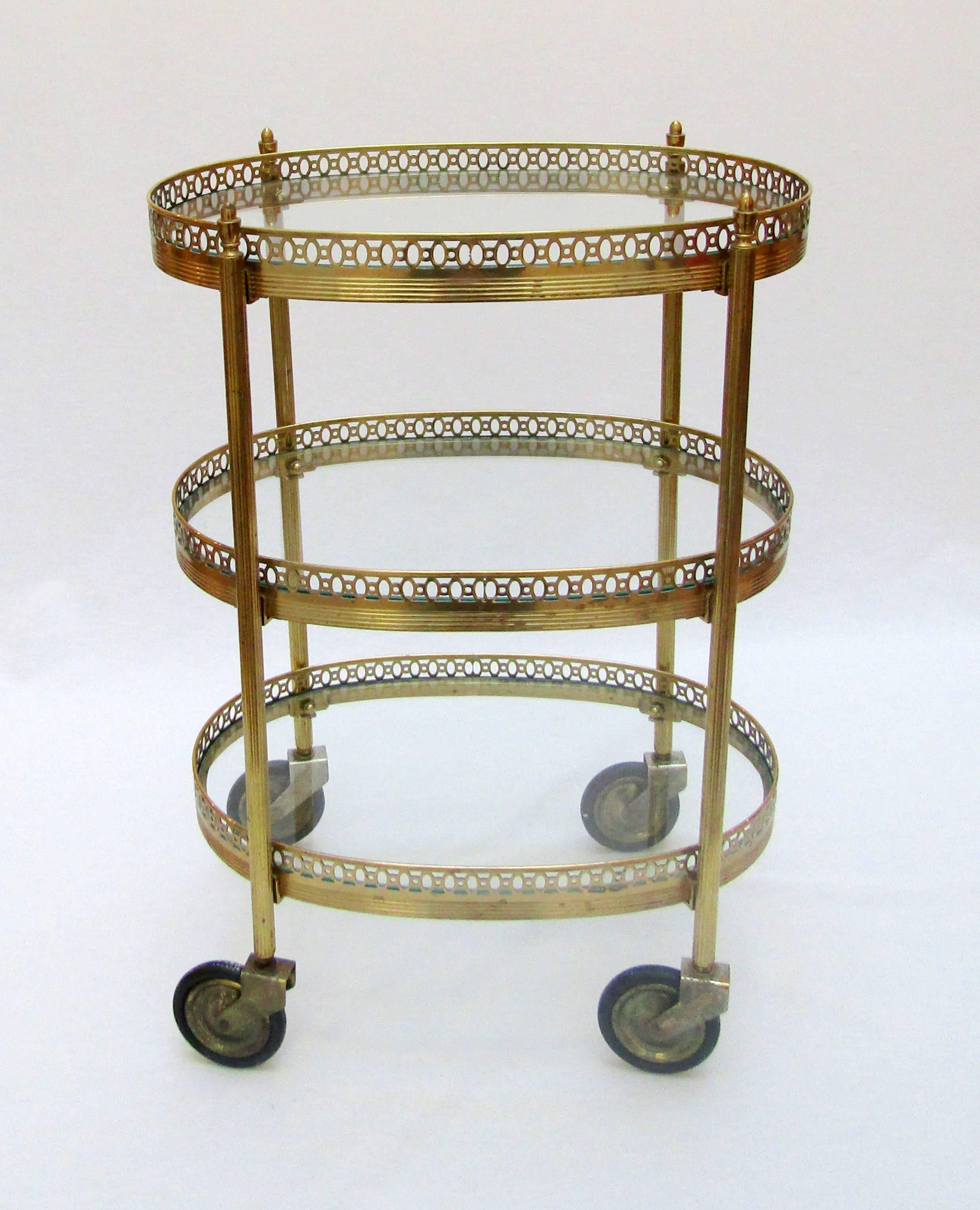 An oval three-tier brass and glass trolley.