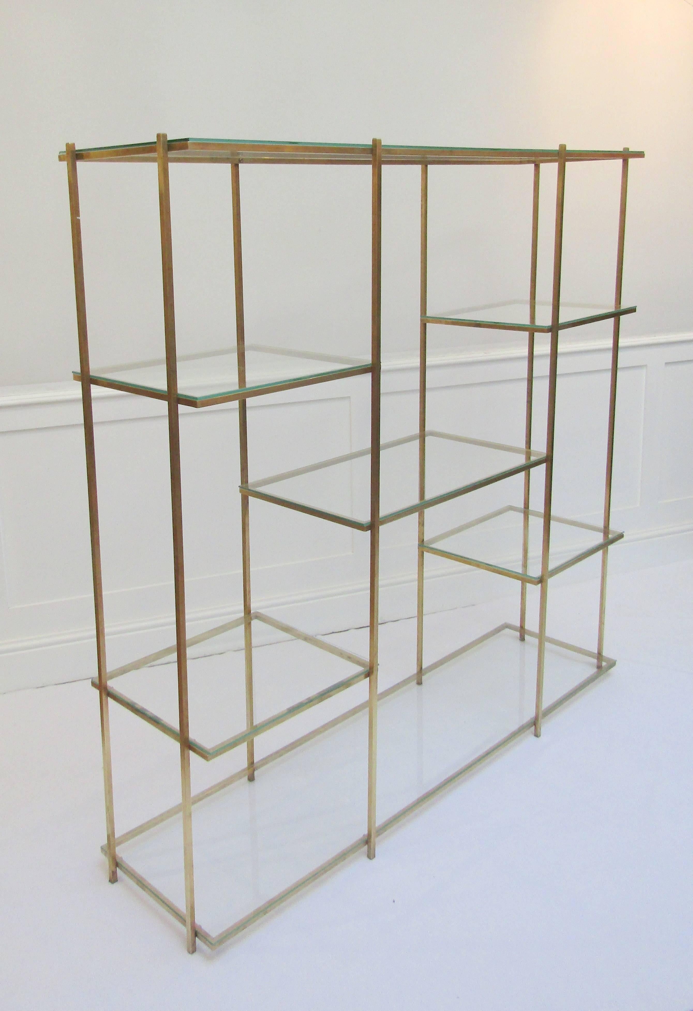 A brass and glass shelving unit.

     