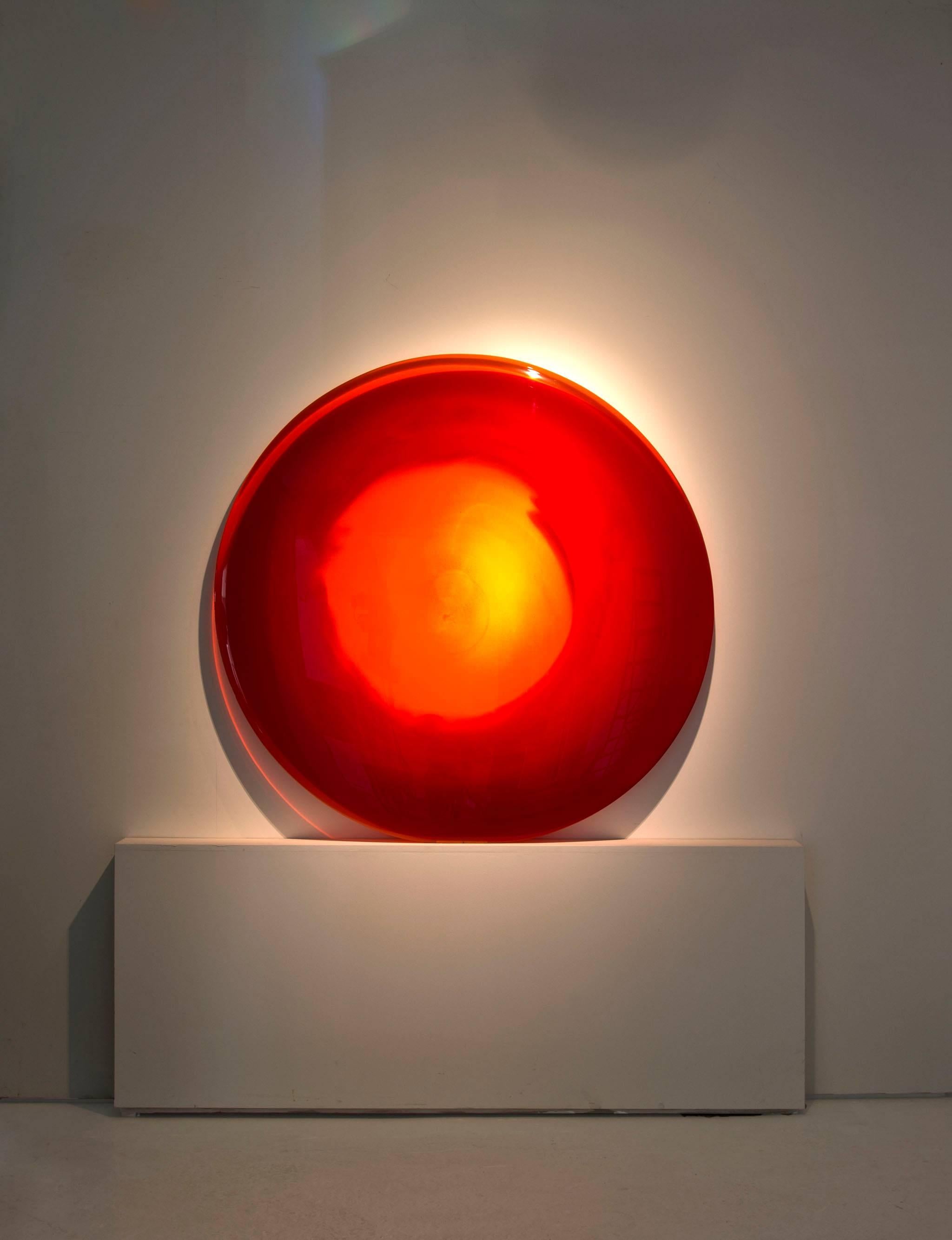 Red Sun is a unique wall sculpture made from specially formulated glass at Danny Lane's studio.
The large glass sculpture has an opaque ring of deep red around the outer edge. The glass transforms to lighter toned translucent oranges and yellows