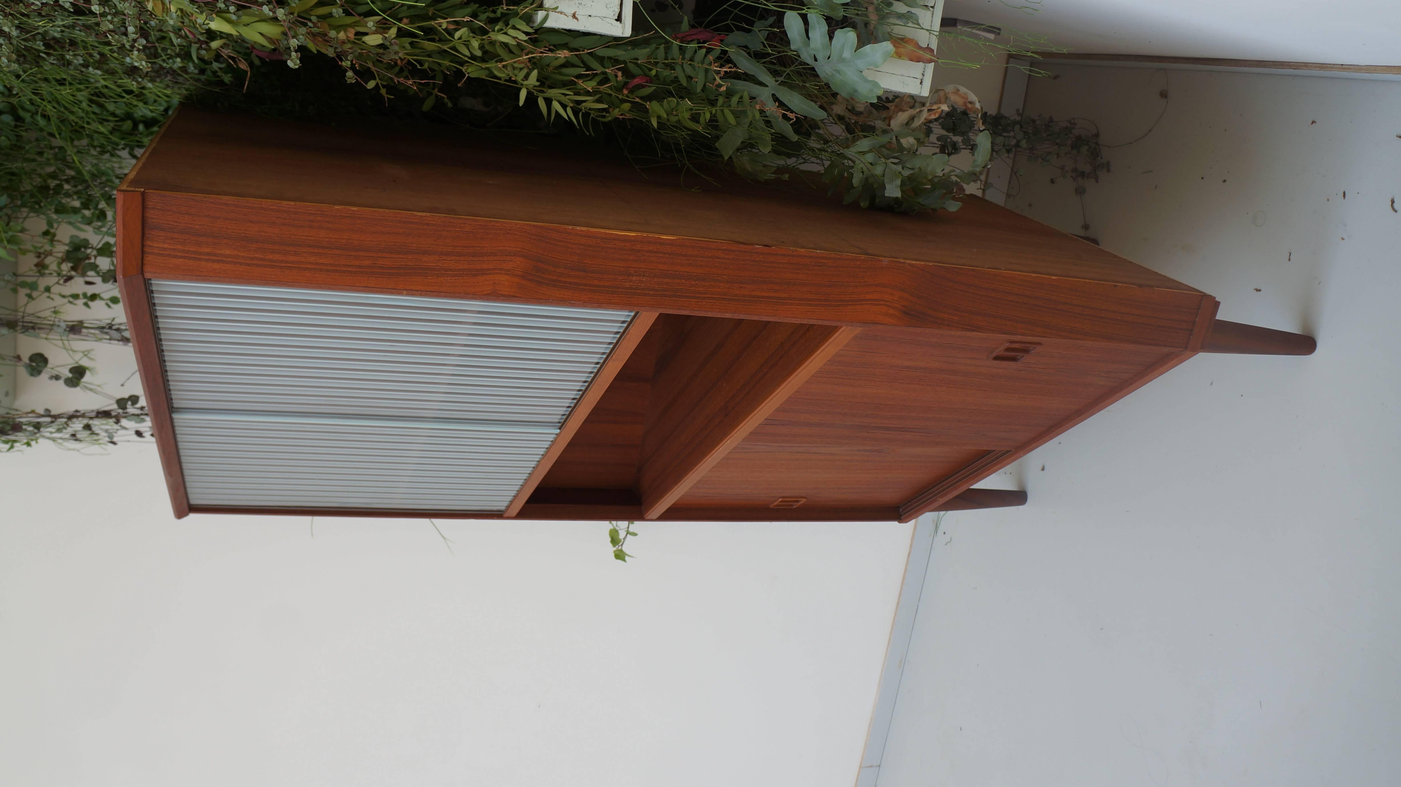 Beautiful unique teak wooden corner cupboard with two glass sliding doors and two wooden sliding doors. Behind the doors there are two shelves.