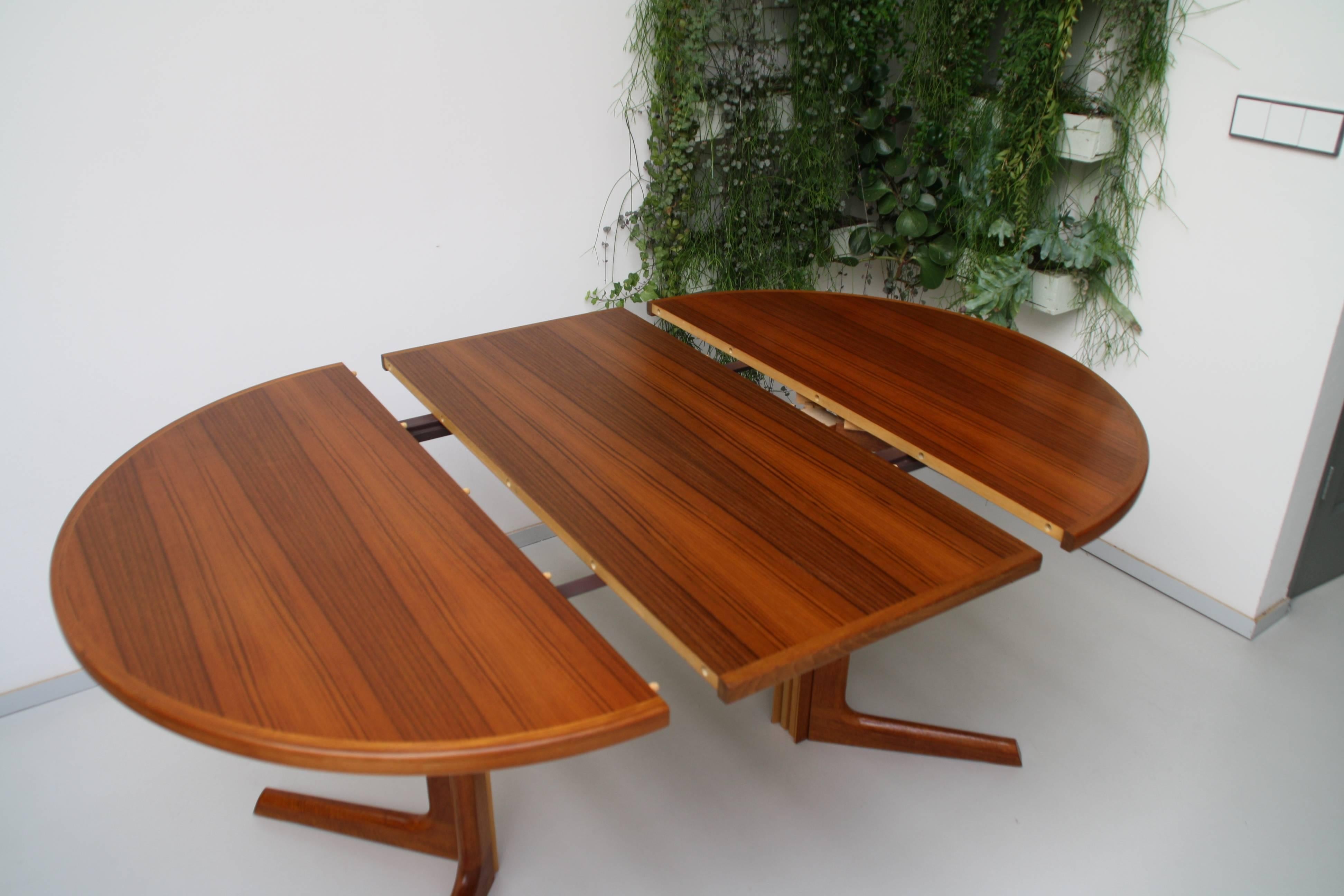 Beautiful teak wooden Danish design dining table. From a round table extends with extra leave to oval shape. Designer Niels Otto Møller. For Gudme Møblefabrik (stamped), Denmark.