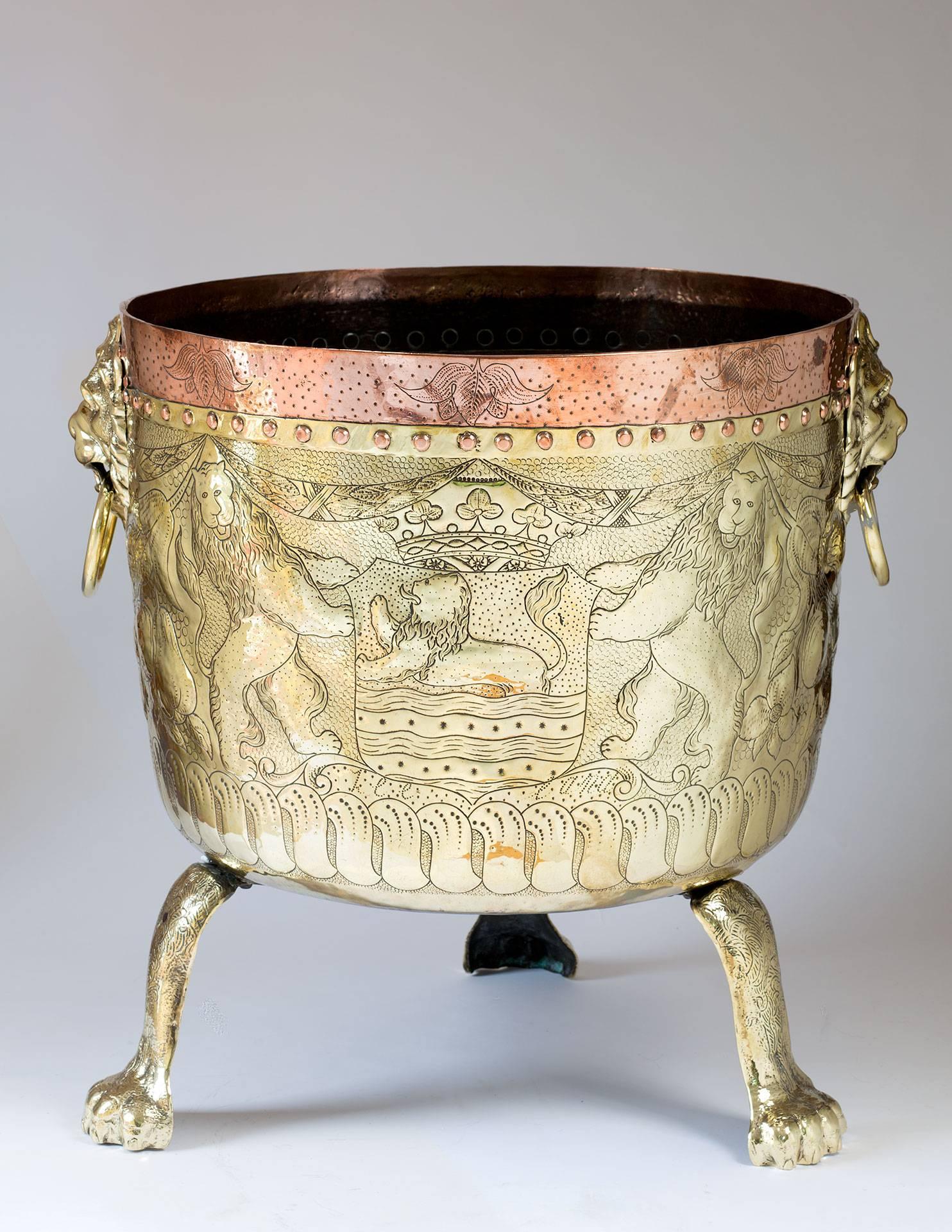 Dutch, brass with copper banded embossed and highly detailed extra-large round planter or wine cooler with brass cast lion mask handles. Decorated with coats of arms and supported by three hairy paw cast feet.
The beveled glass top is a new