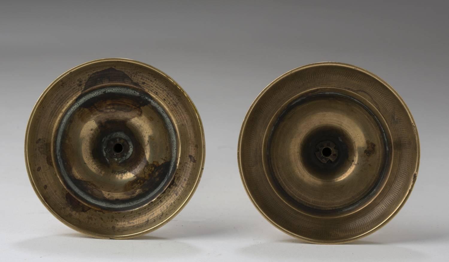 English, brass pair of round base seamed taper candlesticks 4.75″ H, 2.75″ base diameter, circa 1750.
They usually sat on the pulls of a secretary reflecting light from the mirrors and used to soften sealing wax or for travelling due to their size.