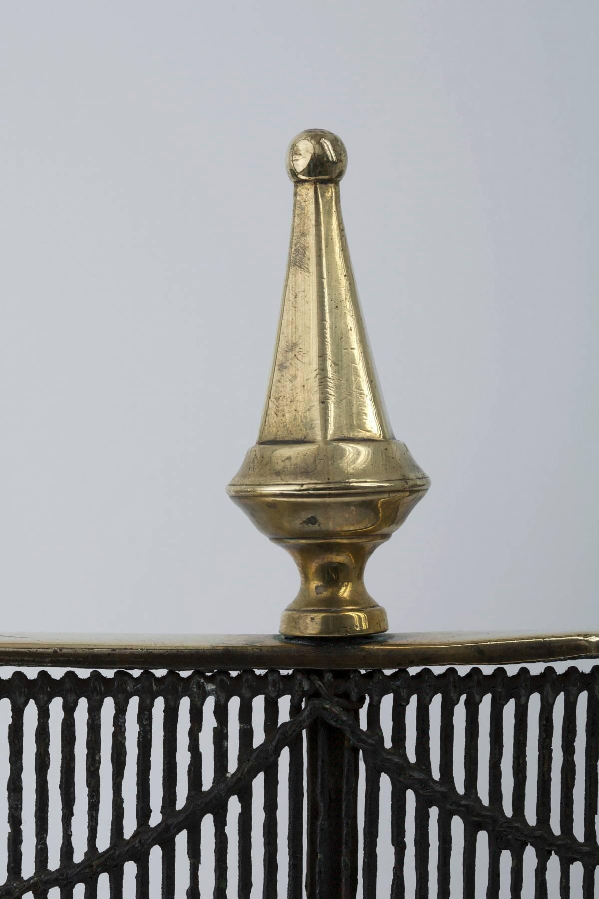 English, wire with brass rail period fire fender with three steeple top finials as both feet and rail decoration, 30.5″ L, 17.5″ H, 12.0″ D, circa 1780.