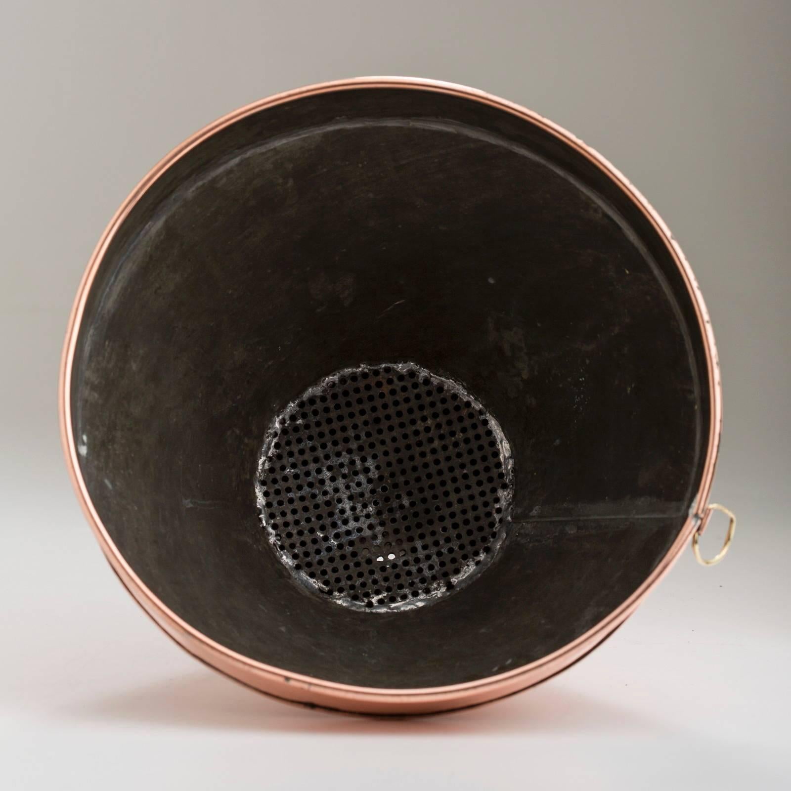American, copper industrial size funnel with interior sieve, folded over seam.
 Would make a great pendant light in the kitchen 13.5″ H, 10.25″ diameter, circa 1890-1900.
