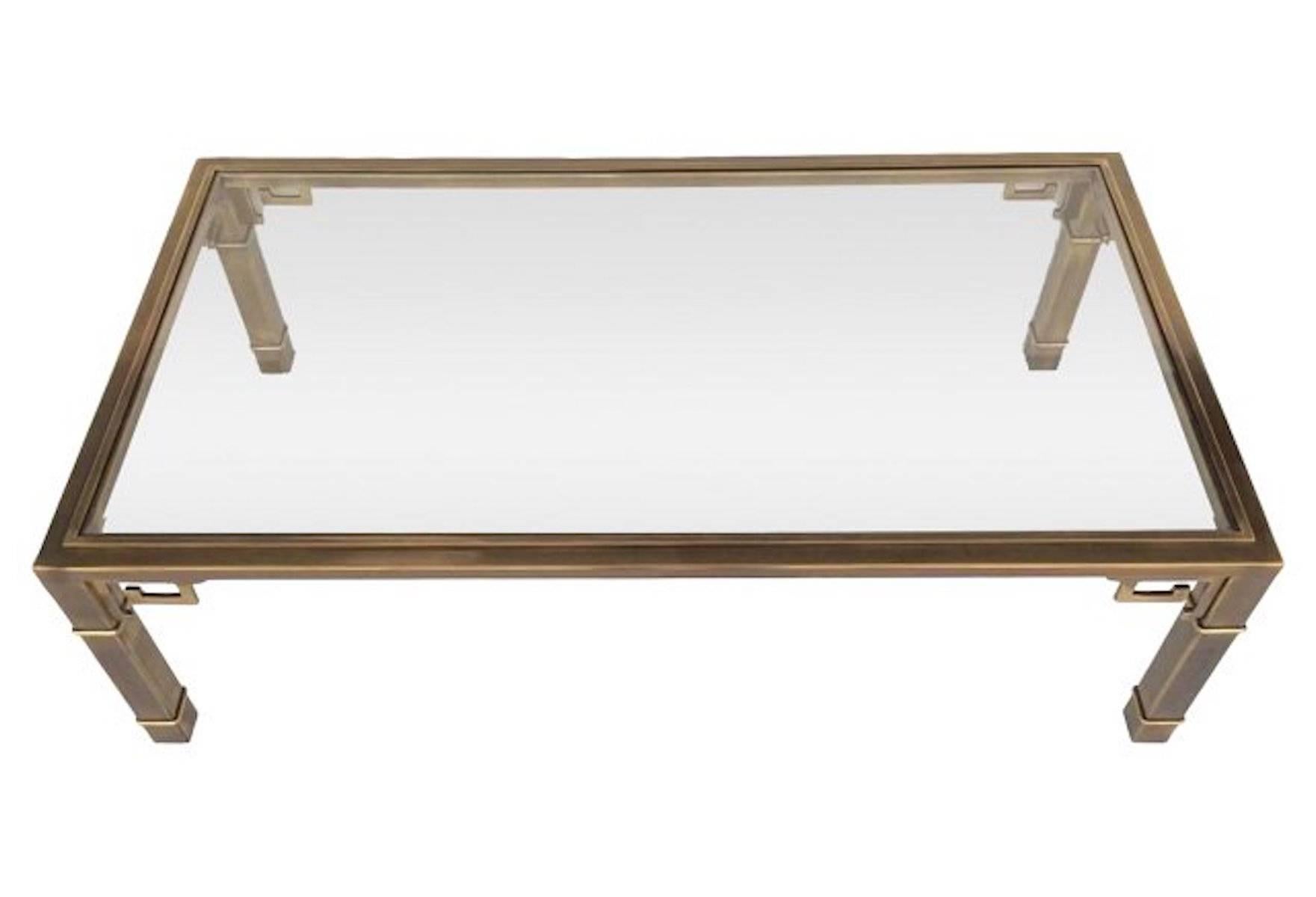 1970s Greek-key brass and glass cocktail table by Mastercraft. Original beveled glass top. Light wear to original glass.