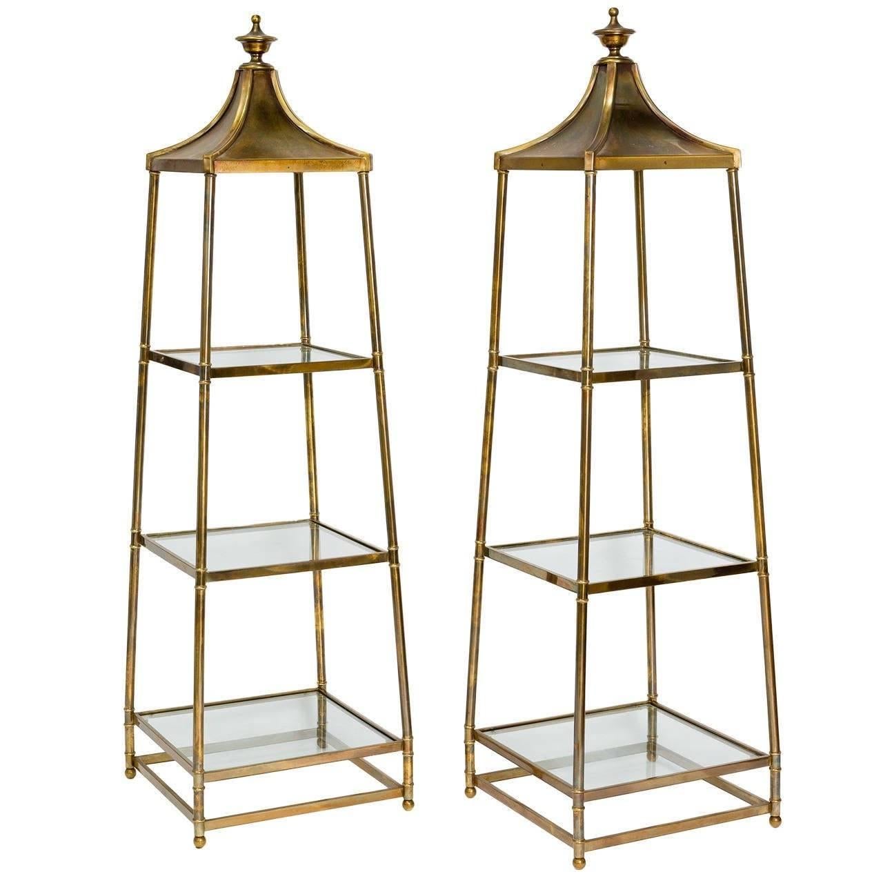 Pair of burnished brass obelisk style étagères by Mastercraft. Each piece has three glass shelves. Brass finials. No makers mark.