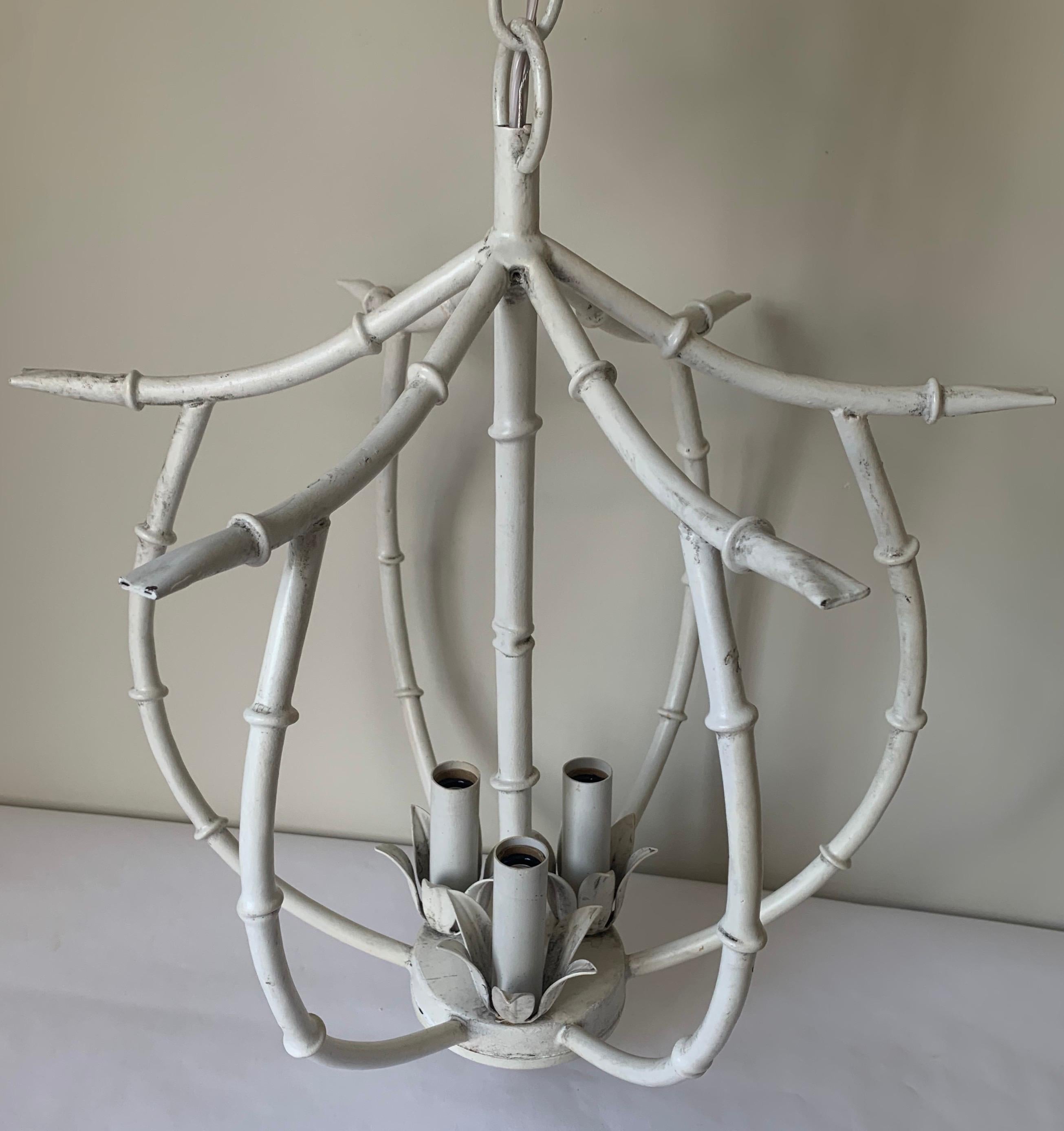 White faux bamboo metal petite chandelier. Newly repainted in an antique white finish. Newly rewired with new chain and canopy painted to match. 36”L chain included. Fixture takes three chandelier bulbs (not included).
