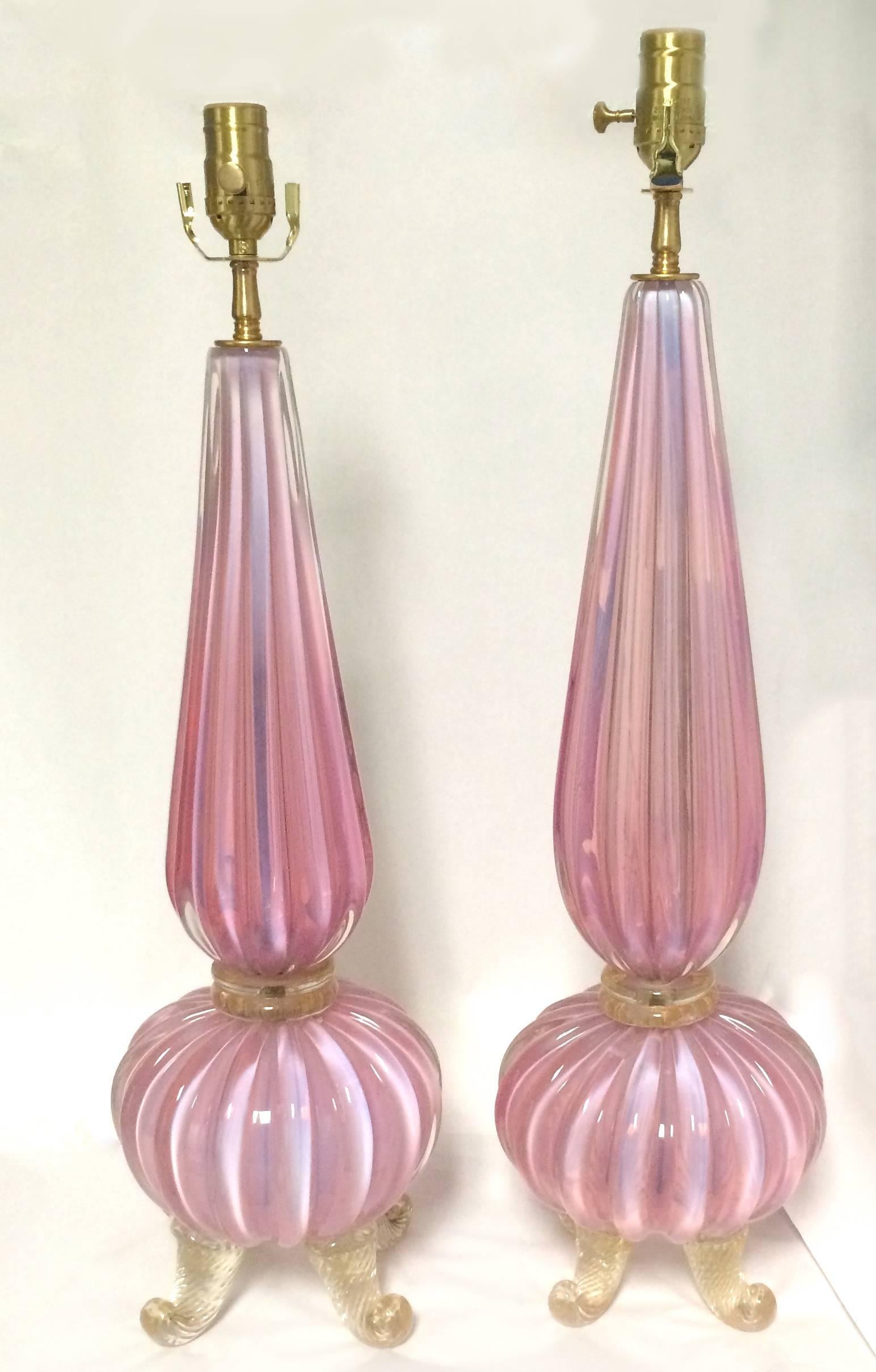 Pair of Mid-Century Murano pink glass table lamps by Barovier & Toso. Pink opalescent ribbed glass. Curvy gold flecked dolphin-footed base. Newly rewired, each lamp takes one standard bulb.
There is a 0.5