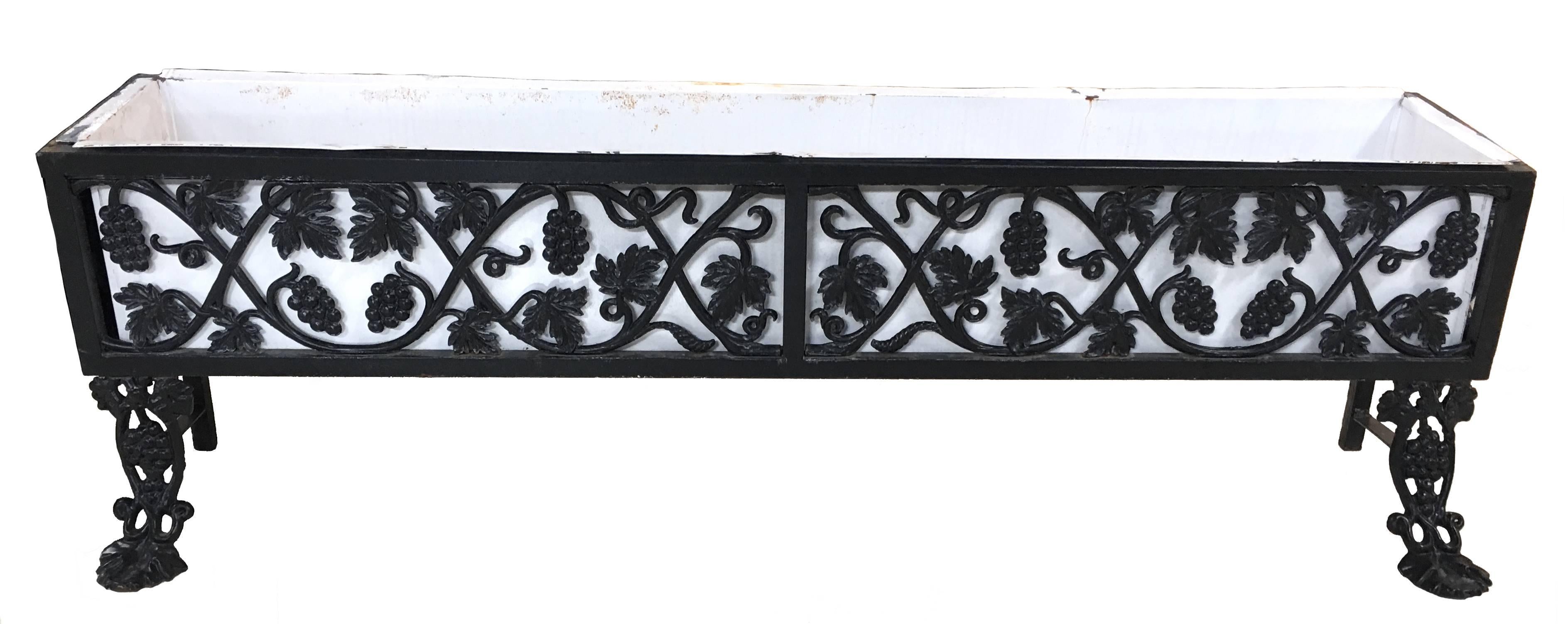 Pair of cast iron box planters with black ivy, grape and leaf pattern. From a waterfront Greenwich, Connecticut estate. Front curved front feet. Removable contemporary powder-coated white metal liners with drainage holes. The liners have light