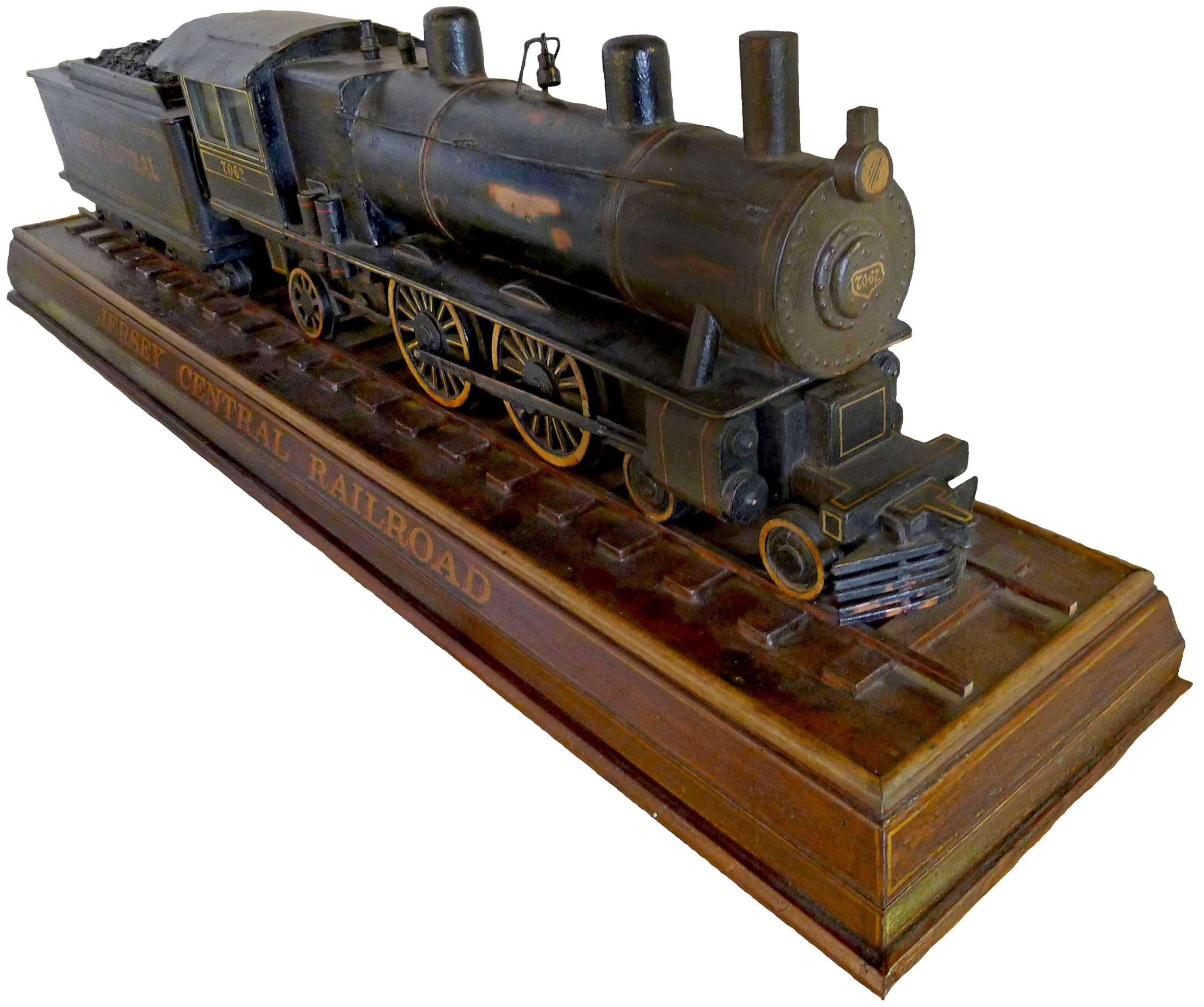 John Elder model Jersey Central Railroad train. Painted copper and wood construction on a wooden base stenciled "Jersey Central". John Elder paper label inside the train cab. 
John Elder was born in Northern Ireland in 1872 and moved to