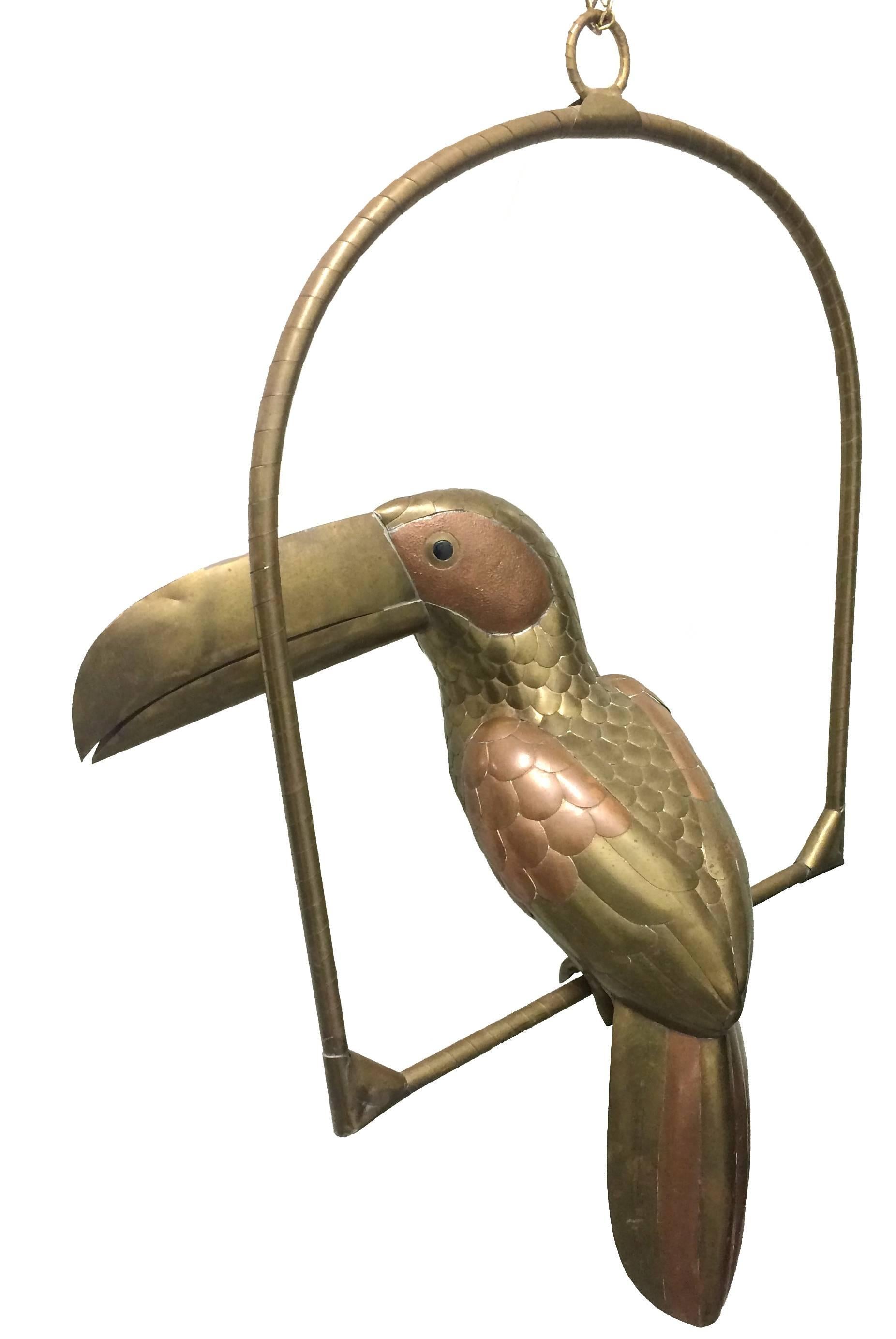 Vintage 1970s copper and brass toucan by Sergio Bustamante. Brass stand with attached hanging chain, 8"L. Stand is 20.5" tall x 17" wide. Unsigned.
