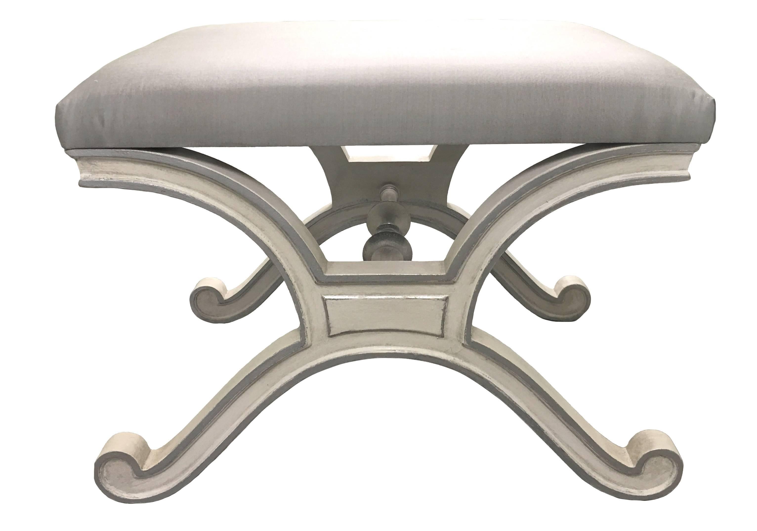 Pair of Dorothy Draper for Henredon Heritage Hollywood Regency style benches. Newly painted in an antique white finish with silver painted detailing. Newly upholstered in grey silk fabric. One bench retains original Heritage Henredon label.
