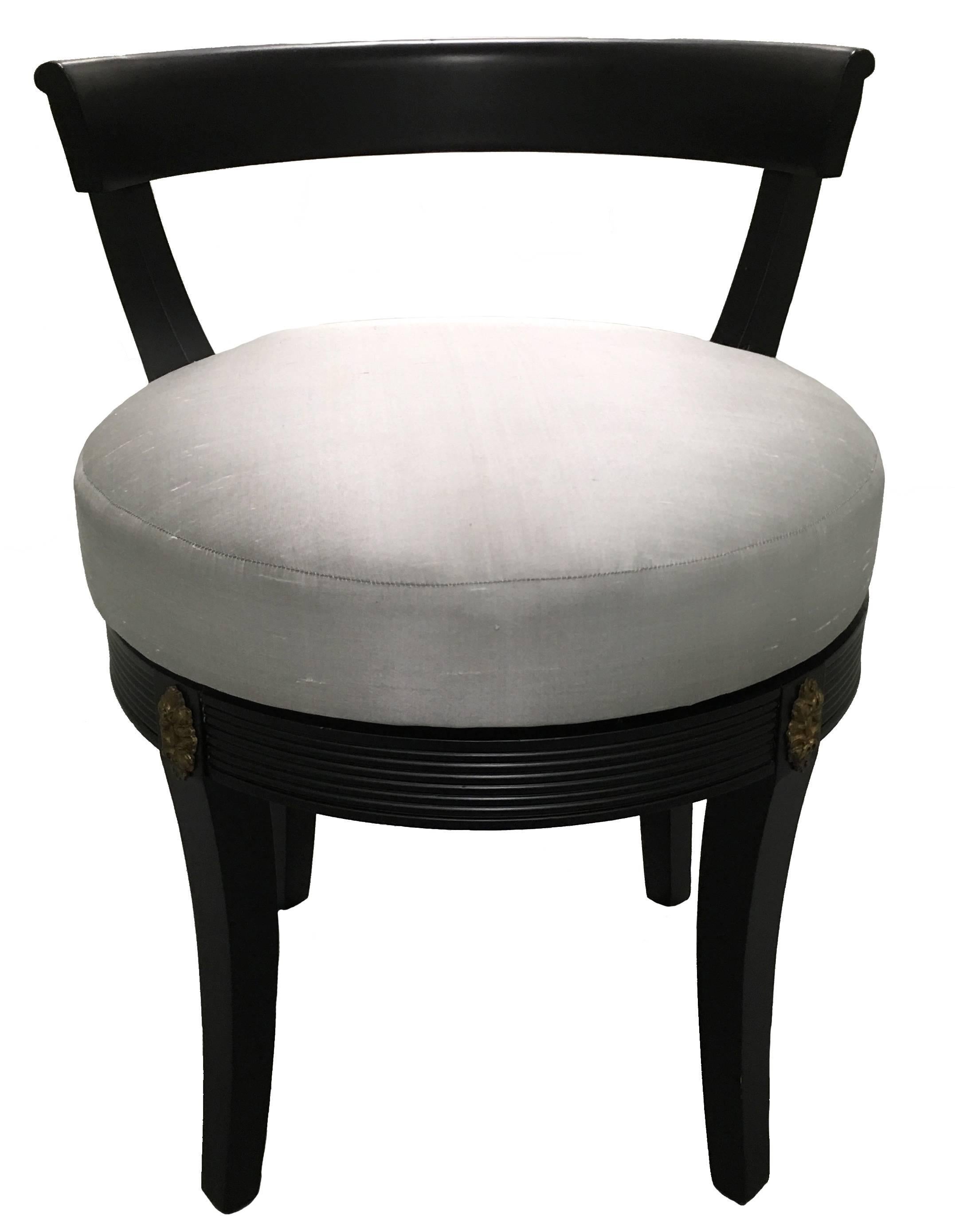 1940s Hollywood Regency style vanity chair. Brass rosette corner detailing. Klismos style design. Swivel seat. Newly painted in black satin finish. Newly upholstered in grey silk fabric.