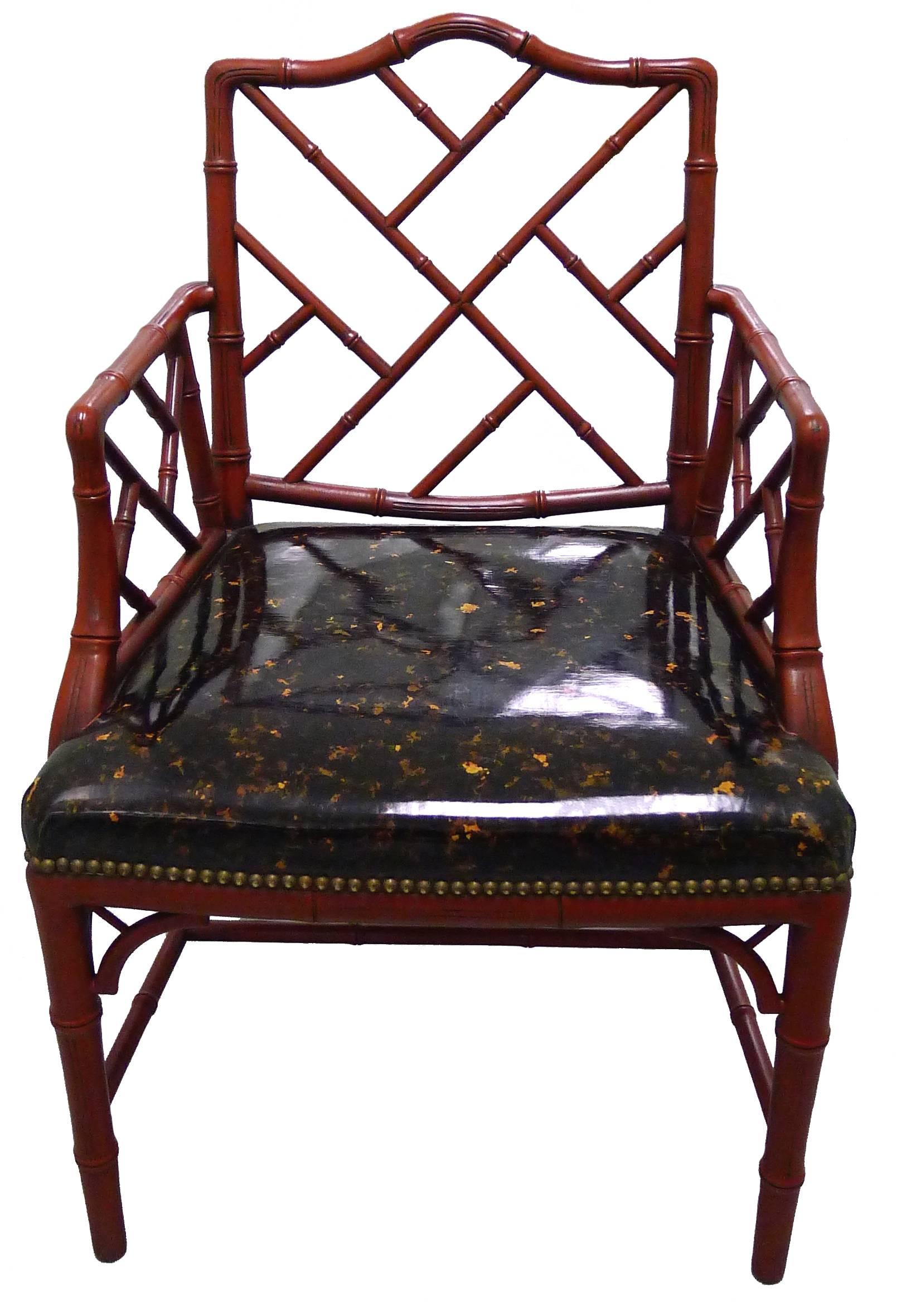 Pair of 1970s faux-bamboo armchairs. Newly painted in an antique red finish. Original faux-tortoise vinyl upholstery and brass nailhead detailing. Measures: Seats 19.5