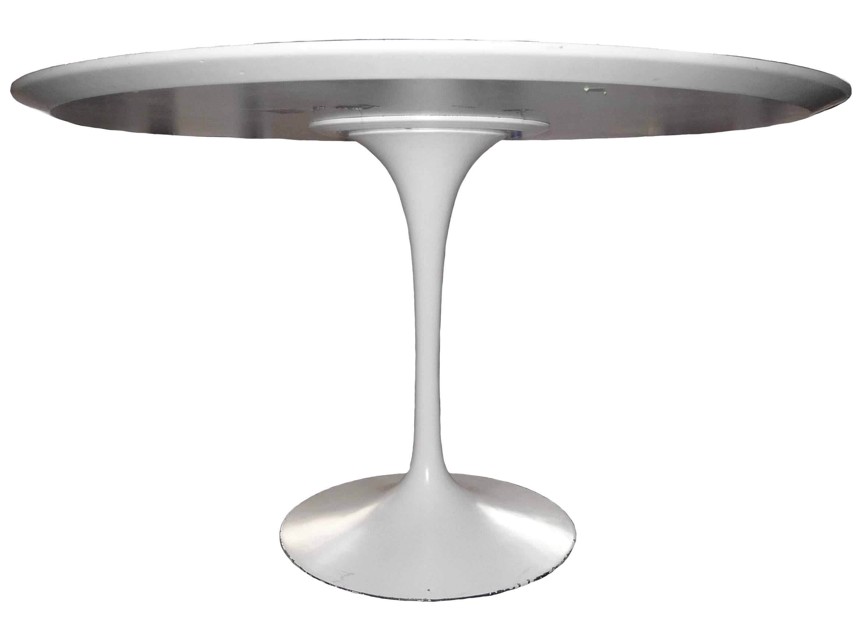 1979 Knoll Saarinen tulip dining table. White laminate top with white metal base. Light wear around the table base and edges of table. Sticker on the underside indicates November 8, 1979 manufacturing date.