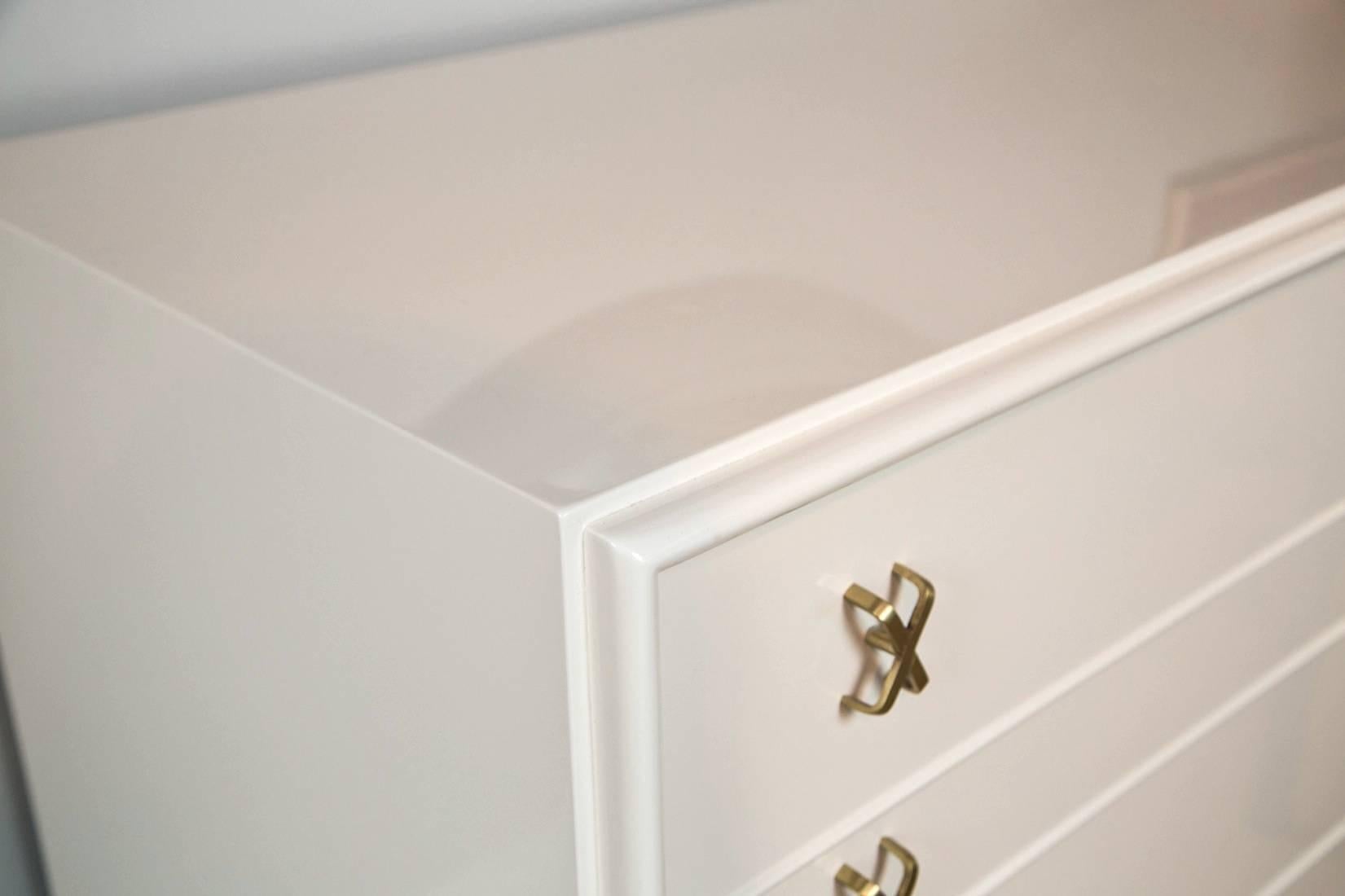 Paul Frankl Mid-Century dresser with brass X-pulls for John Stuart Inc and Johnson Furniture Co. Newly refinished in white lacquer. Original brass X-pulls retain original satin brass finish.