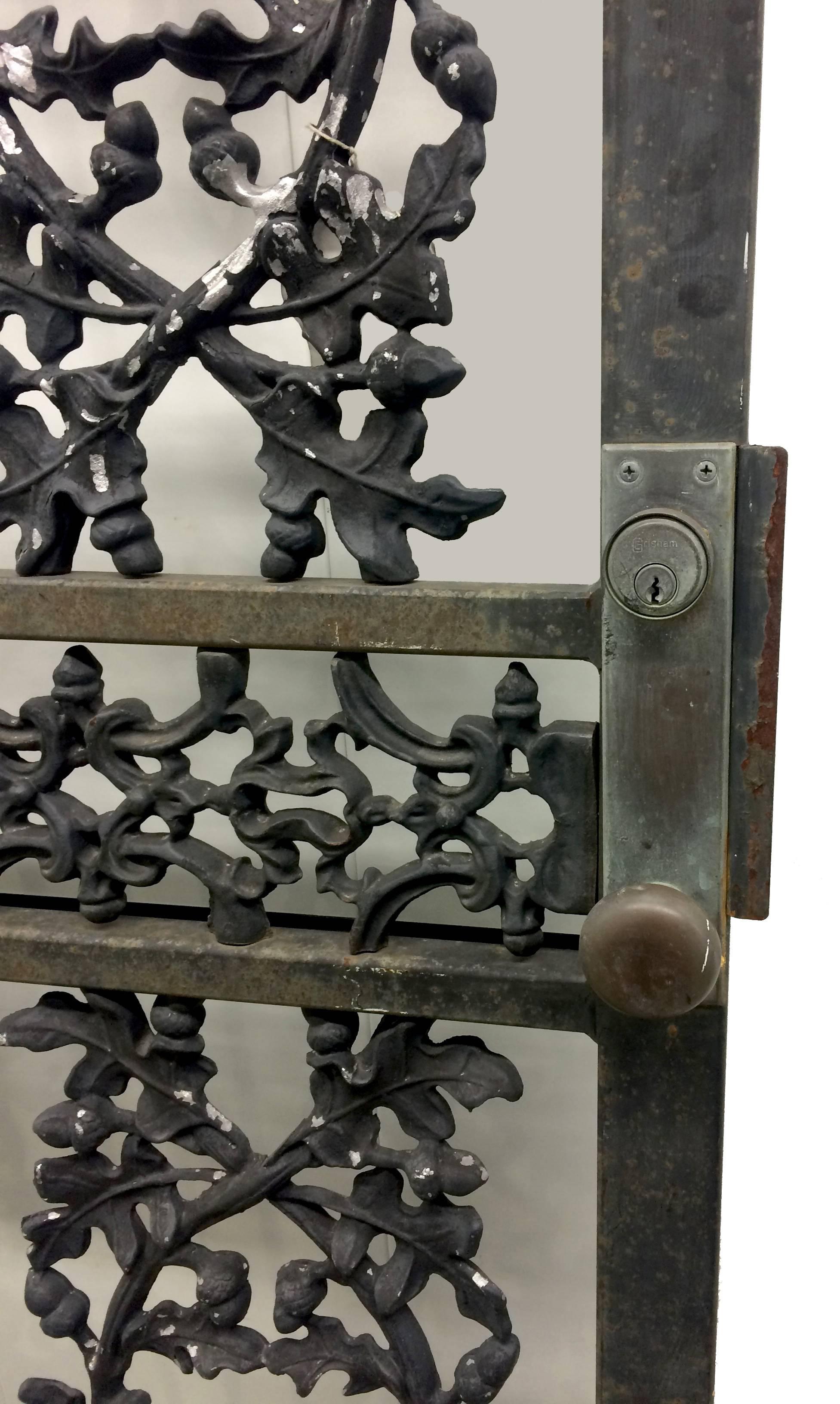 1920s wrought iron oak leaf and acorn motif door. Original black painted finish. Original front door hardware has a knob on the outside and a latch on the inside and a top lock (no key). Door will require new hinges. The interior side of the door