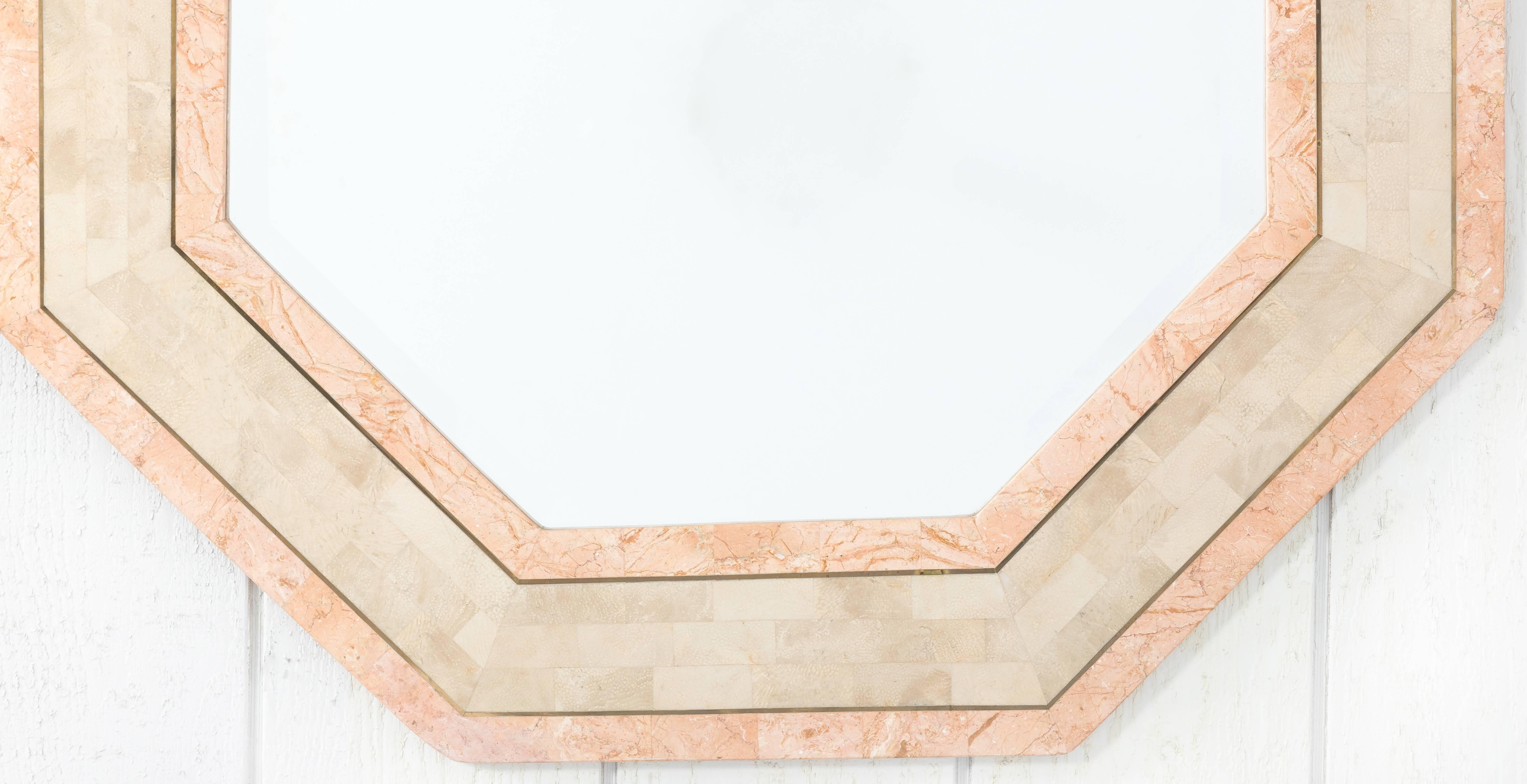 Stone octagonal mirror by Maitland-Smith. Beige and light pink tessellated stone with brass banding. Original beveled mirror. No makers mark.
  