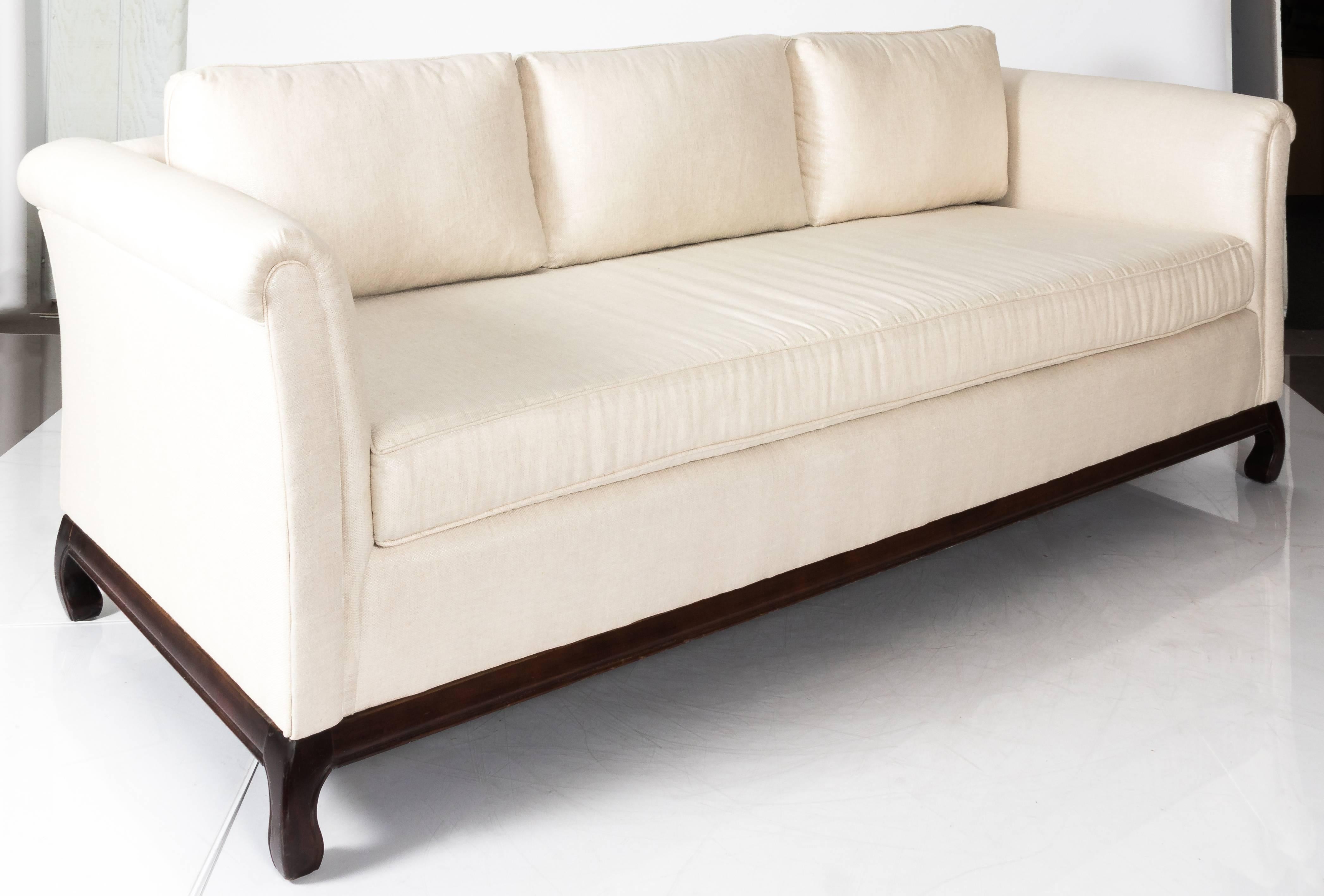 1970s Asian style sofa. Original dark walnut Ming style base. Newly upholstered in off-white metallic linen. New single foam cushion and three back pillows. This item is available to view at The Antique & Artisan Gallery in Stamford, CT.
Measure:
