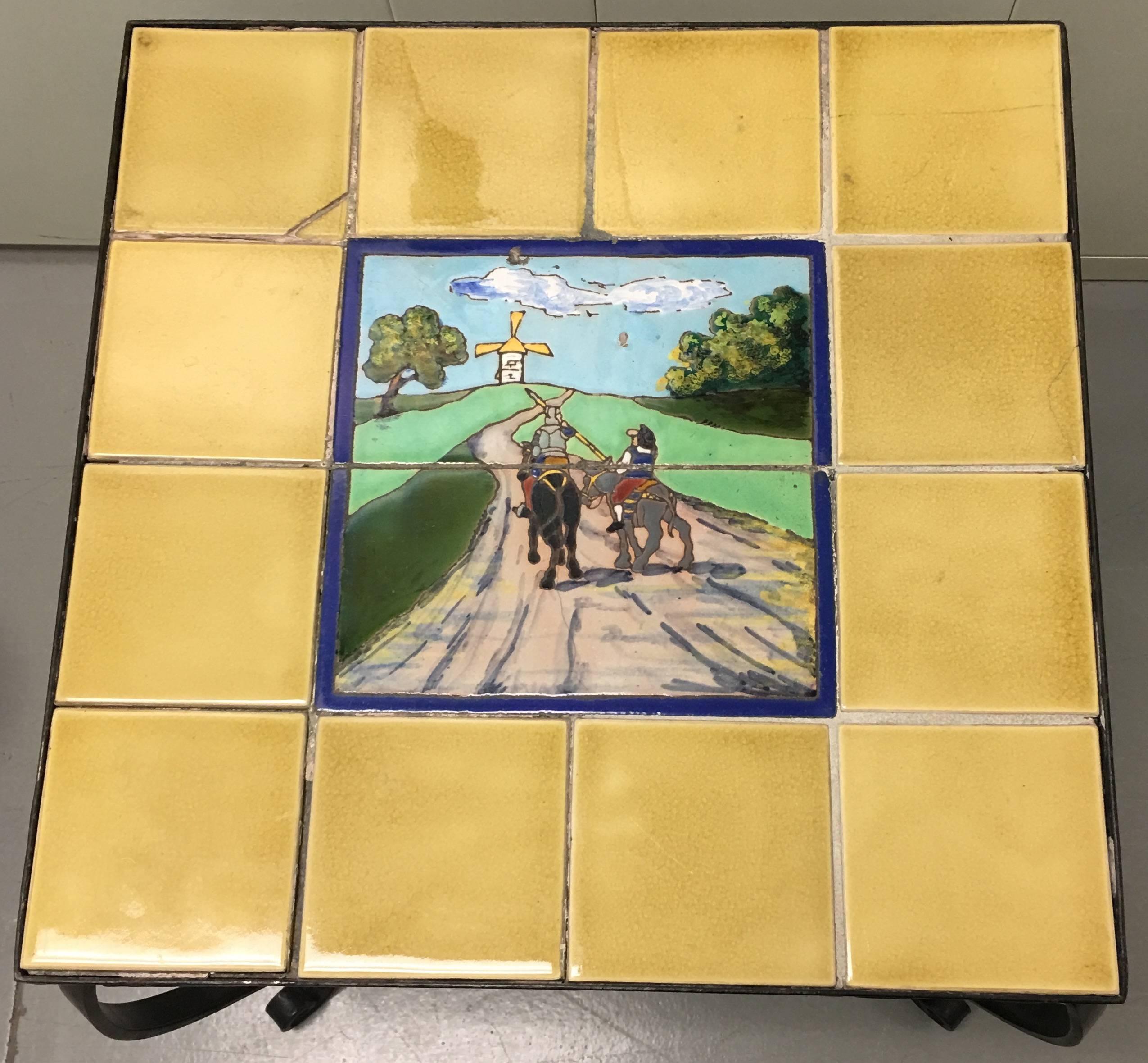 1930s Spanish tile-top wrought iron side table. Ceramic tiles depicting Don Quixote and the Windmill. Black wrought iron table base.