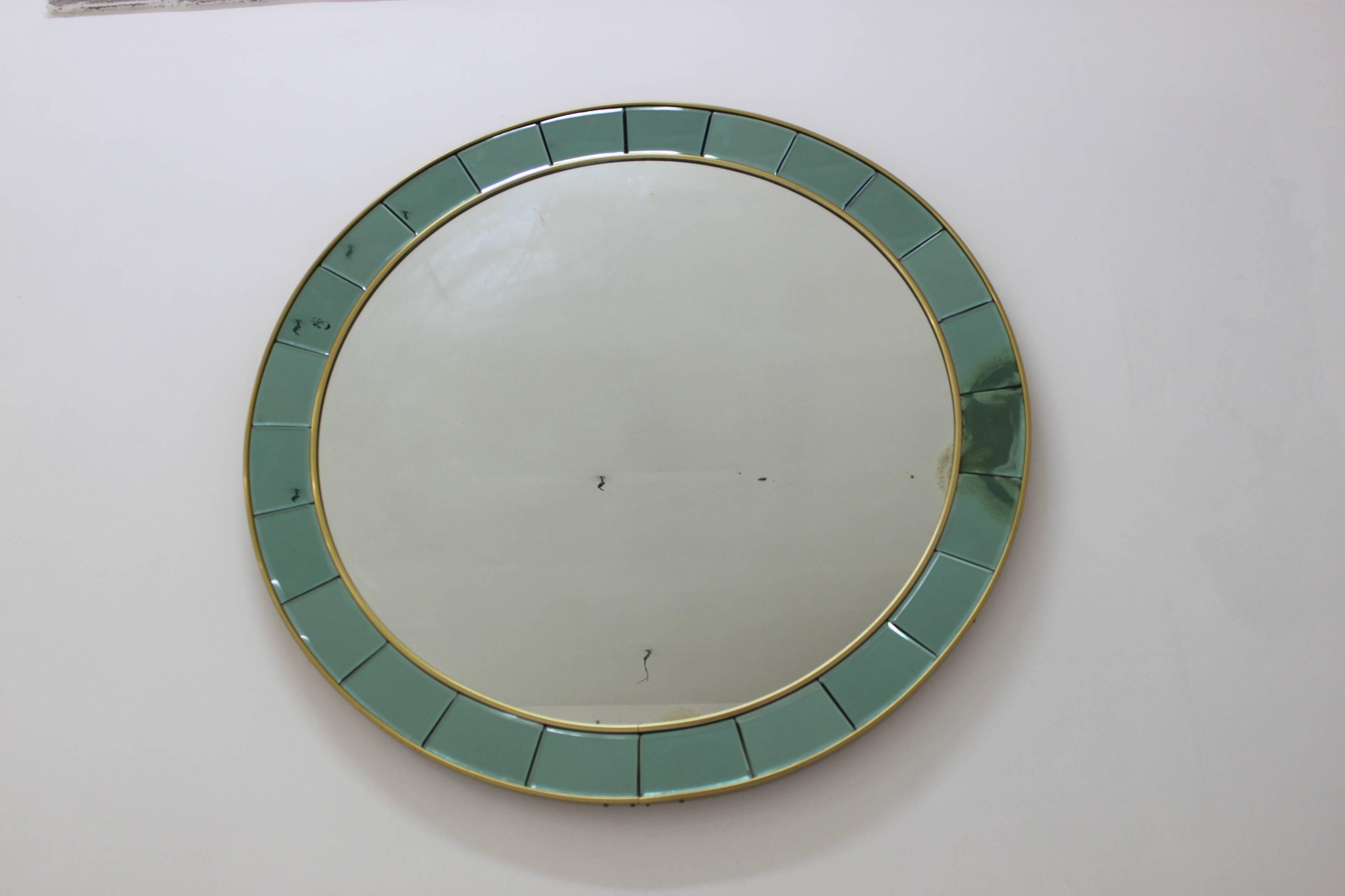 Imposing beautiful round mirror with light blue little mirrors.
Glass surround and brass detailing.
Mixage glass.