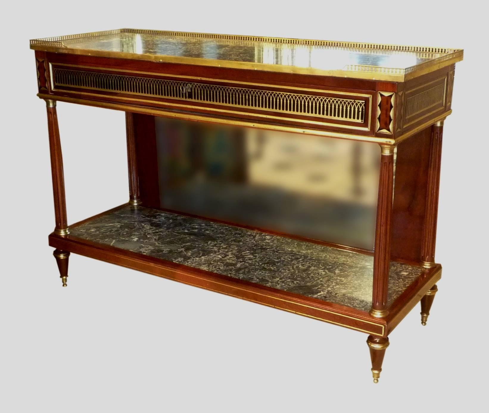 A French Directoire mahogany, brass and gilt bronze console desserte, with two Saint-Anne grey marble tops (one with a small restoration), circa 1800.