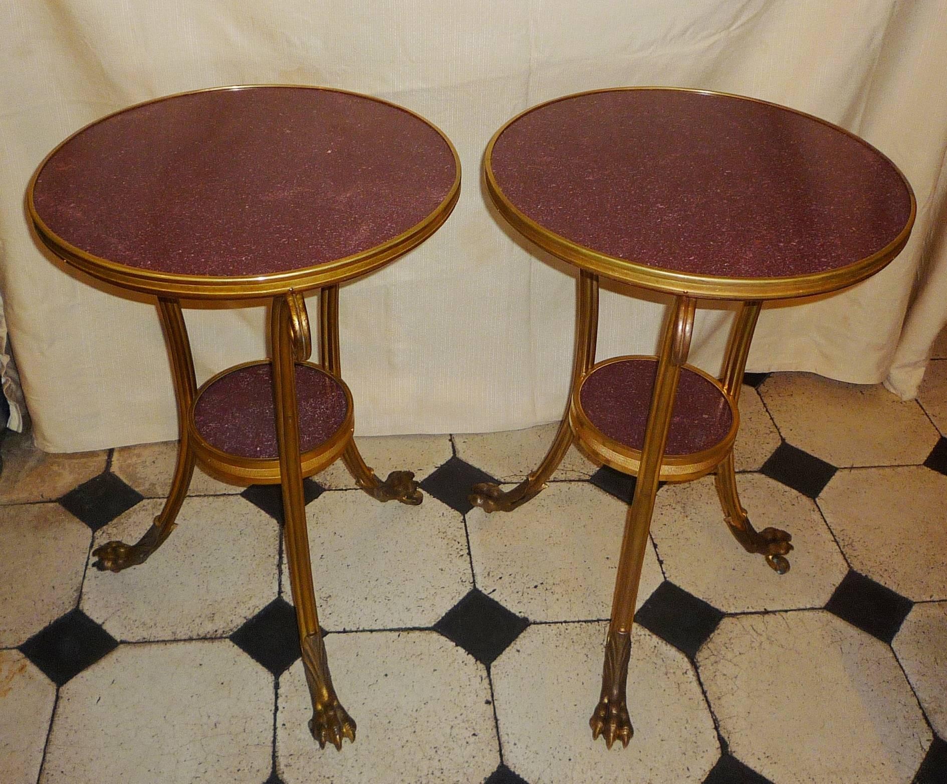 A pair of French Louis XVI style gilt bronze tripod gueridons or side tables, the two tops in Egyptian porphyry, circa 1870 (a very fine Louis XVI style model by Weisweiler.)
   