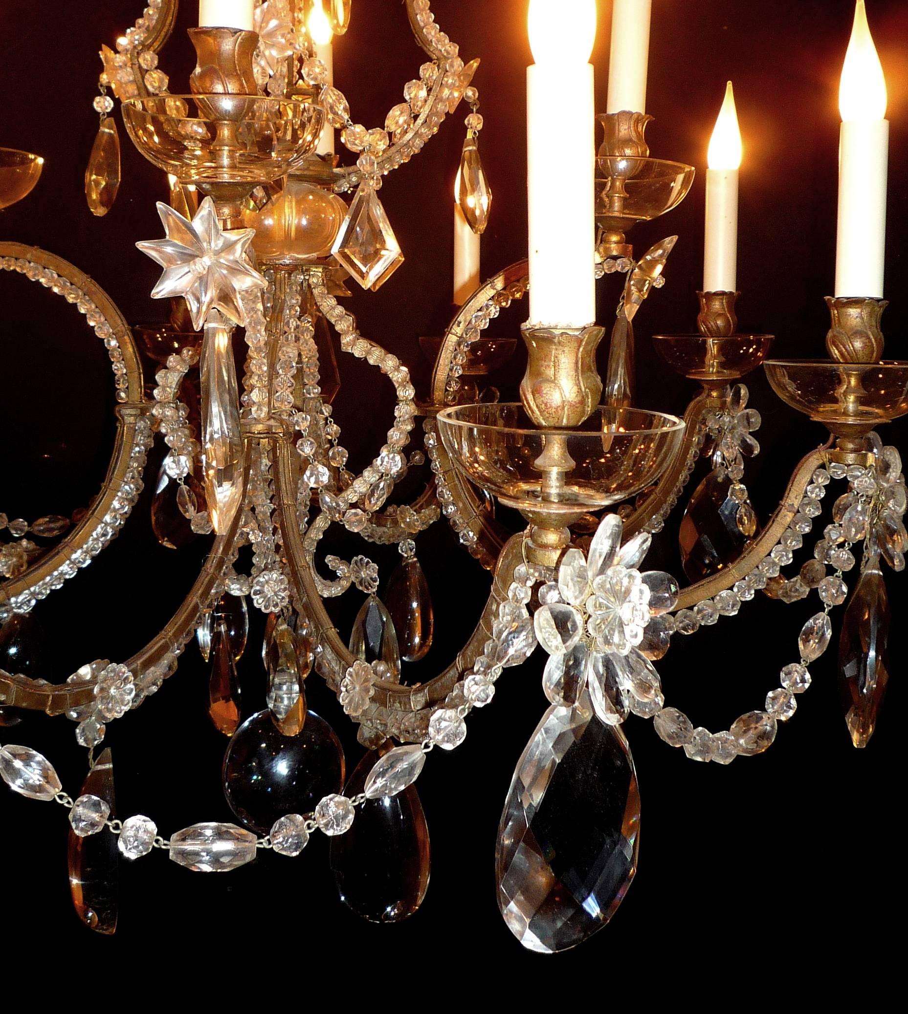 A French gilt bronze, metal and crystal 12-light chandelier by Maison Baguès, circa 1940-1950.