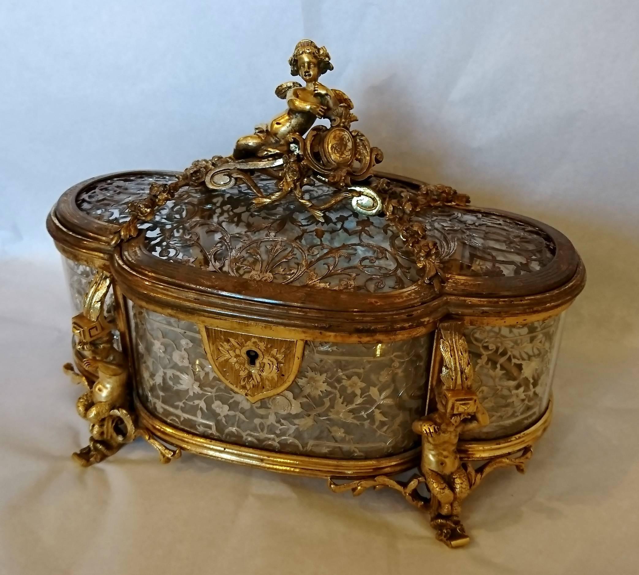 An unusual gilt bronze and silver filigree jewelry casket, with decoration of putti and flowers, signed Alphonse Giroux and Cie, Paris, circa 1865.
Some rubbing to the gold, one glass cracked inside.
 